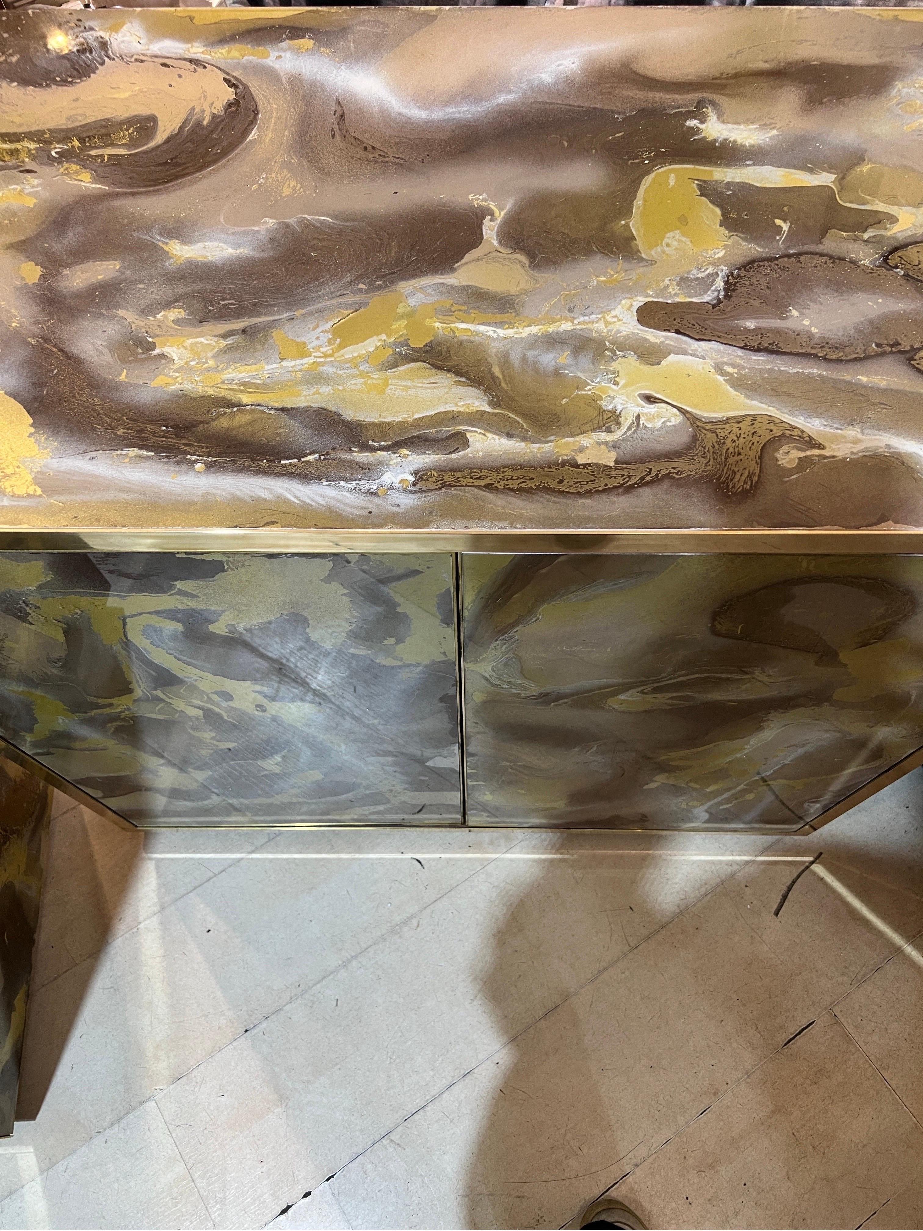 Hand-Painted glass cupboard with brass frames and base. The marbled effect decoration is hand painted on the back of the glass, with brown, gold, yellow and white tones.
One shelf inside.