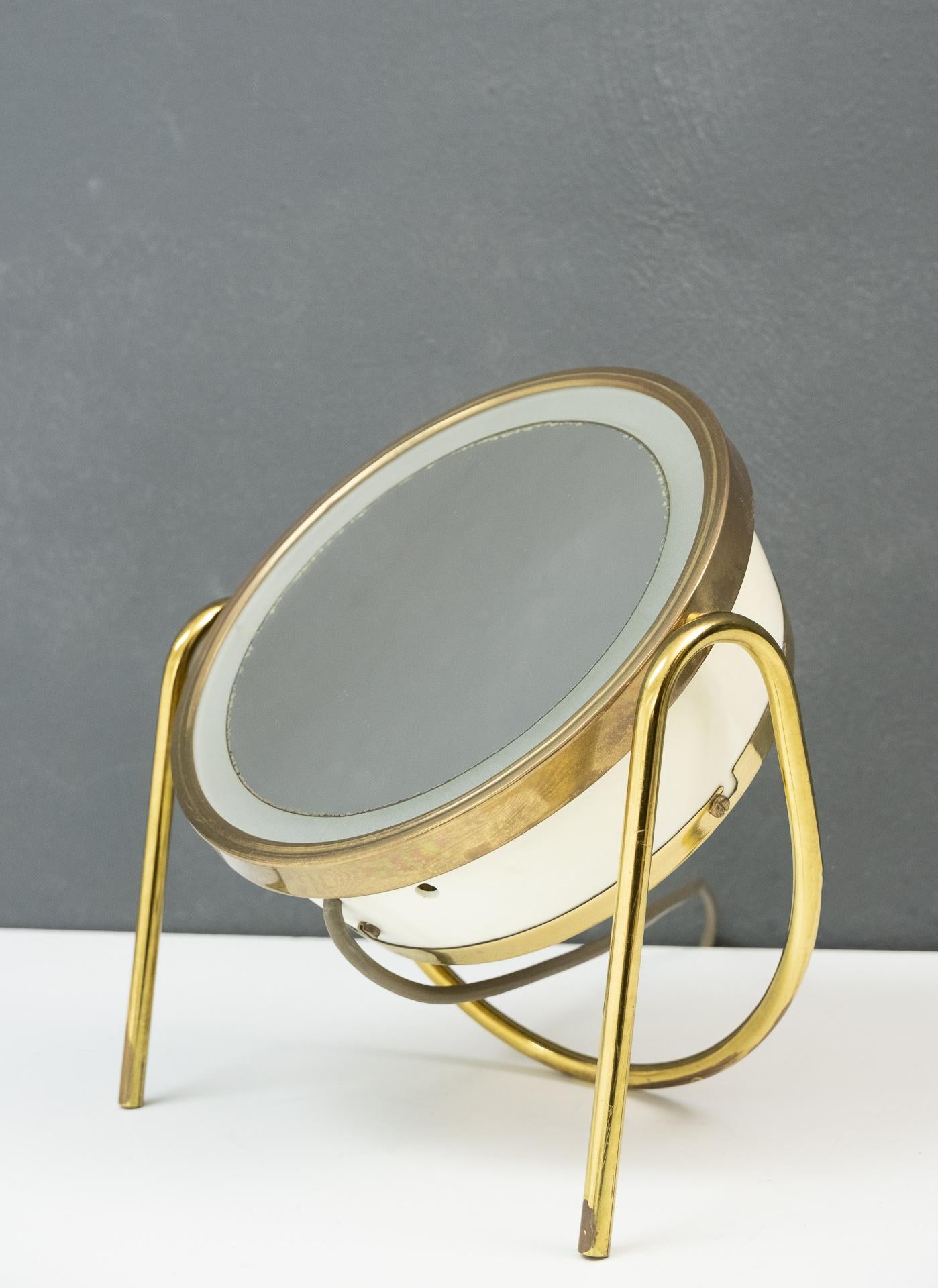 Very nice elegant table vanity shaving mirror. With back lit. Small bulb. Magnified.
Brass and plastic, 1970s, France. Good working condition.