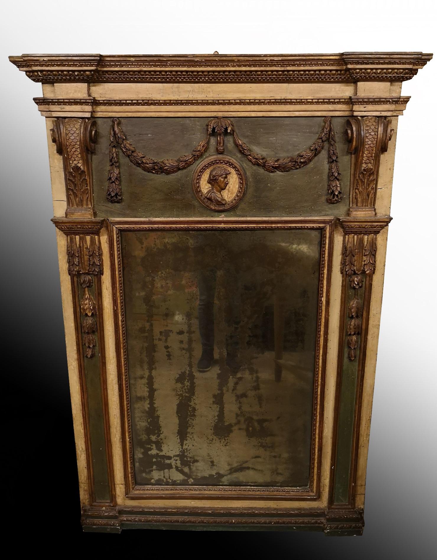 Beautiful mirror in the back of the room in gold and green lacquered wood characterized in the central part by a large medallion within festoons, while festoons with floral motifs stand out on the sides.
An object that alone furnishes the entire