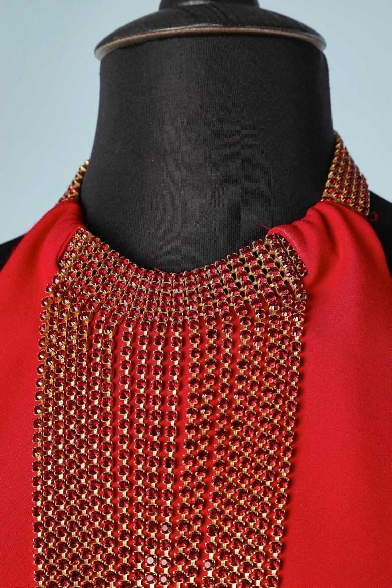 Red backless evening dress with rubis rhinestone neckless. 
Fabric composition: 58% acetate, 42% rayon. 
Invisible zip on the left side. Split middle back, lenght= 60 cm
Adjustable chain behind the neck with brand. The lenght of the fabric on the
