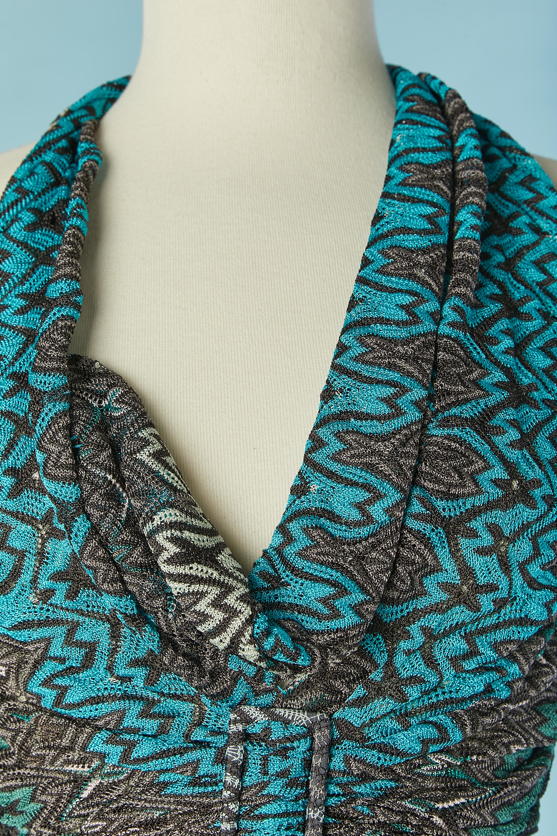 Abito lungo in maglia jacquard senza schienale. Composizione principale della maglia: 100% rayon. Fodera: 91% chiffon di seta, 9% elastan. 
Chiusura con zip invisibile sul lato sinistro. 2 fibbie rivestite in tessuto (una al centro della vita e una