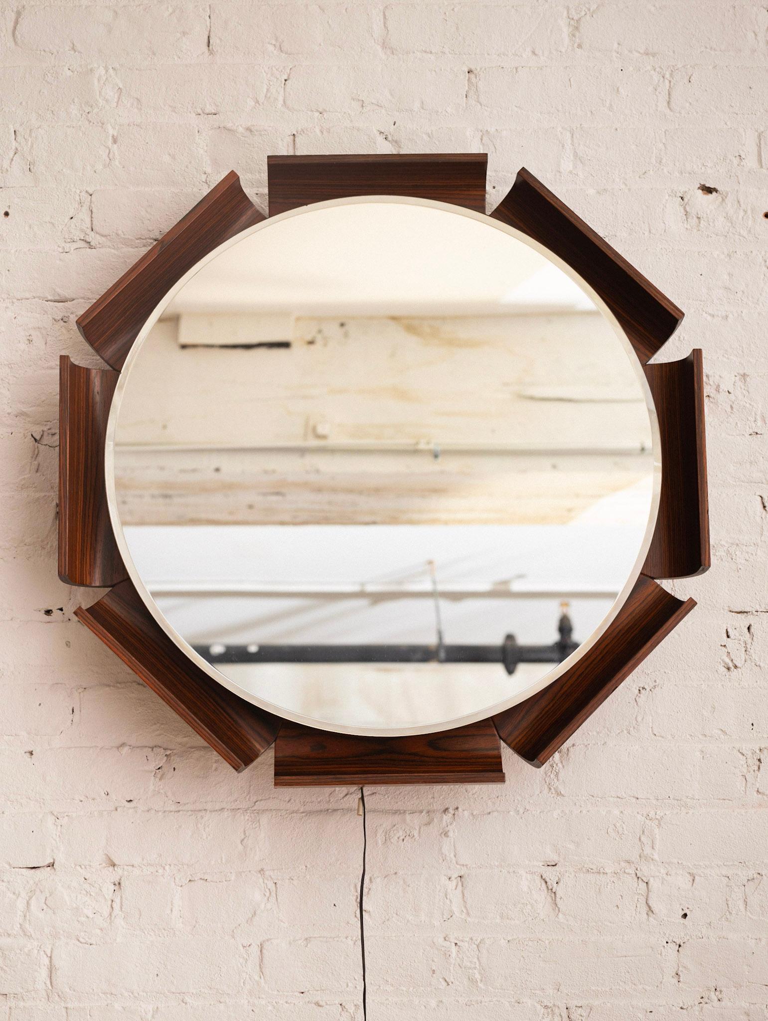 A round rosewood wall mirror by ISA Bergamo. Rosewood 