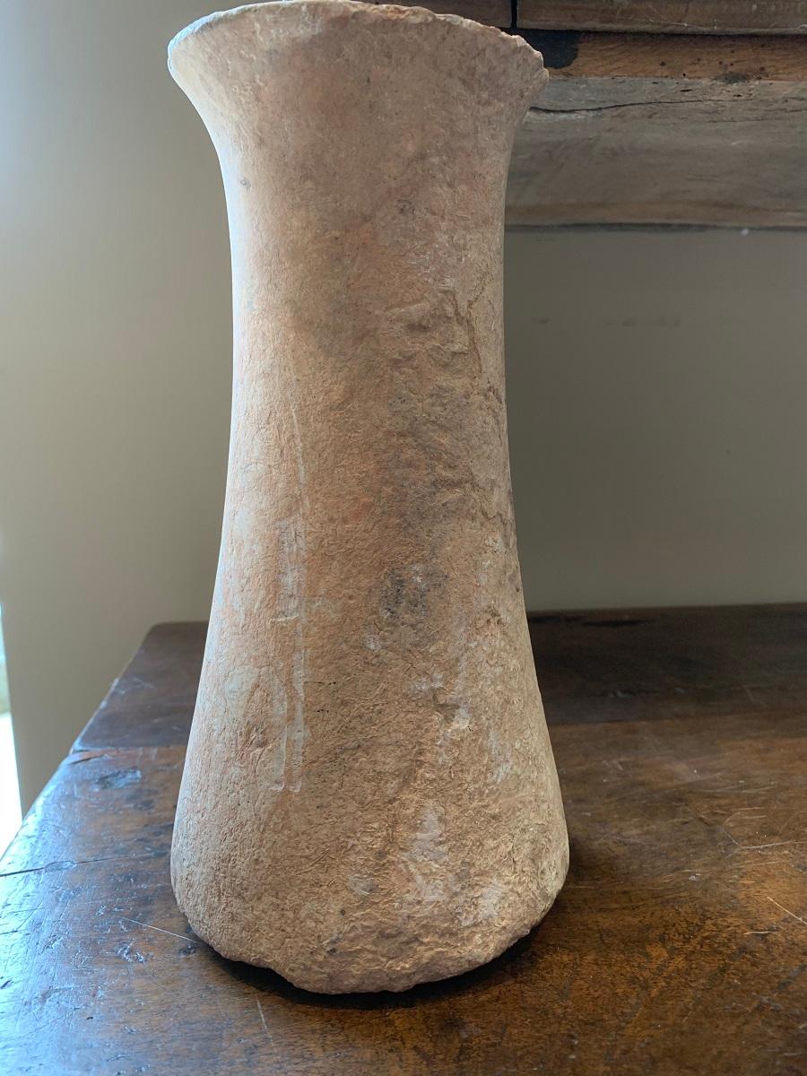 Bactrian marble column idol, circa 3000-2000 Bc. It has a elegant tapering form with a undeep groove running on the top and bottom. The marble is strikingly vained in a cream pink color. It has incrustation on the side where it laid on the sand and