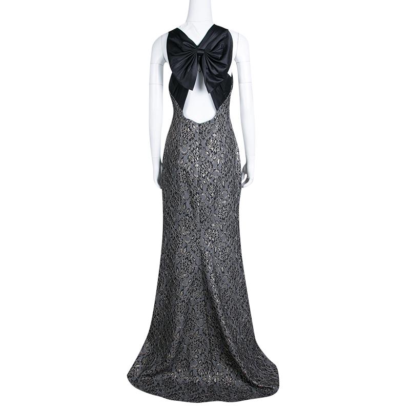 This sleeveless evening gown by Badgley Mischka Collection is a statement piece that can give you a celebrity-like look. The outfit has a structured shape with a metallic finish and a feminine, black bow that beautifies the rear. From the label's