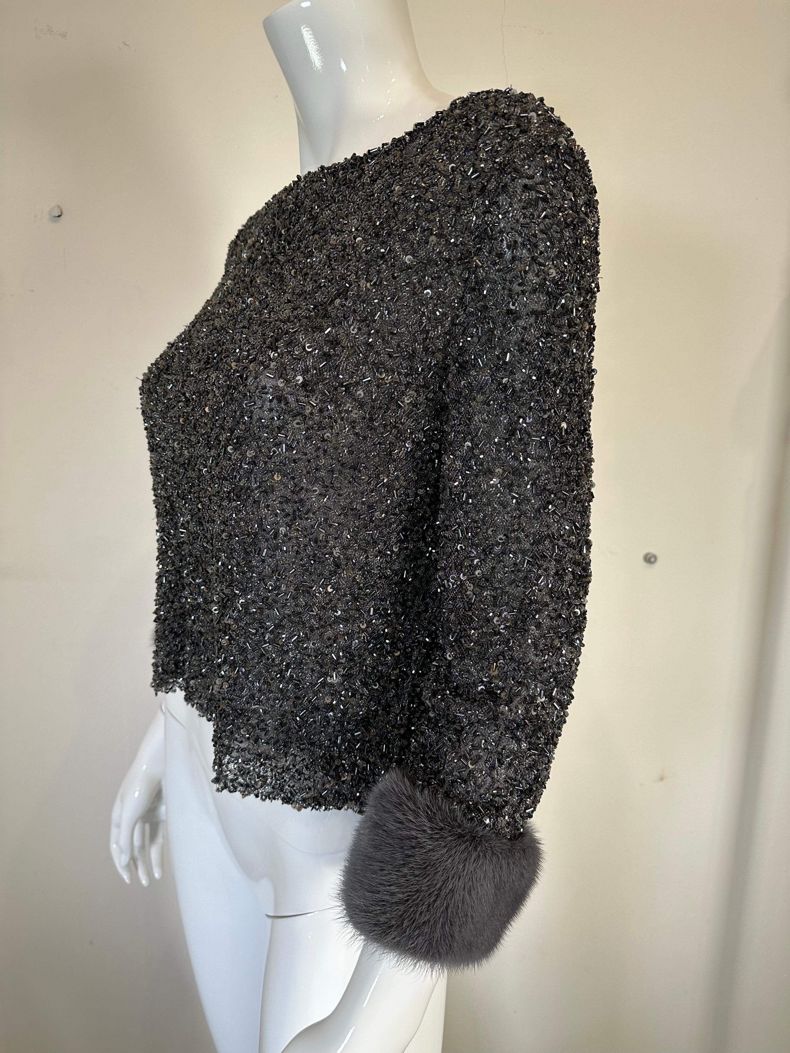 Badgley Mischka glittery black/steely grey  glass beaded evening top, with bateau neckline, 3/4 length sleeves and grey mink cuffs. 
This beautiful top is lined in grey silk chiffon. Pull on style, closes at the side with a zipper. Perfect with
