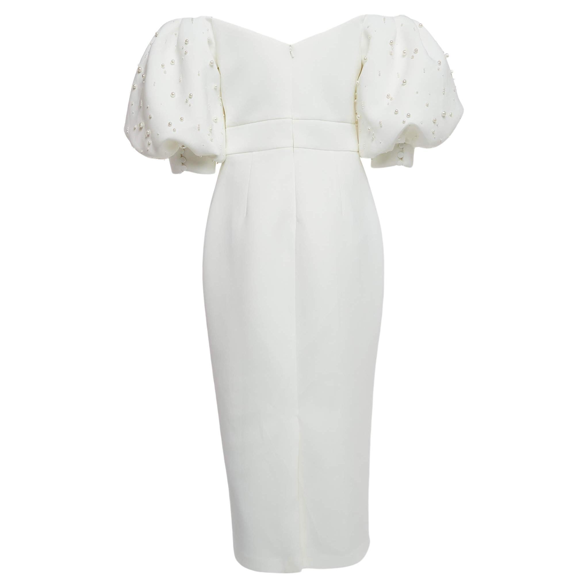 This stylish ivory dress with pearl embellishment exudes elegance and sophistication. Its flattering midi length offers a versatile option for various occasions. Delicate and exquisitely feminine, the dress is perfect for evenings, dates, and even a