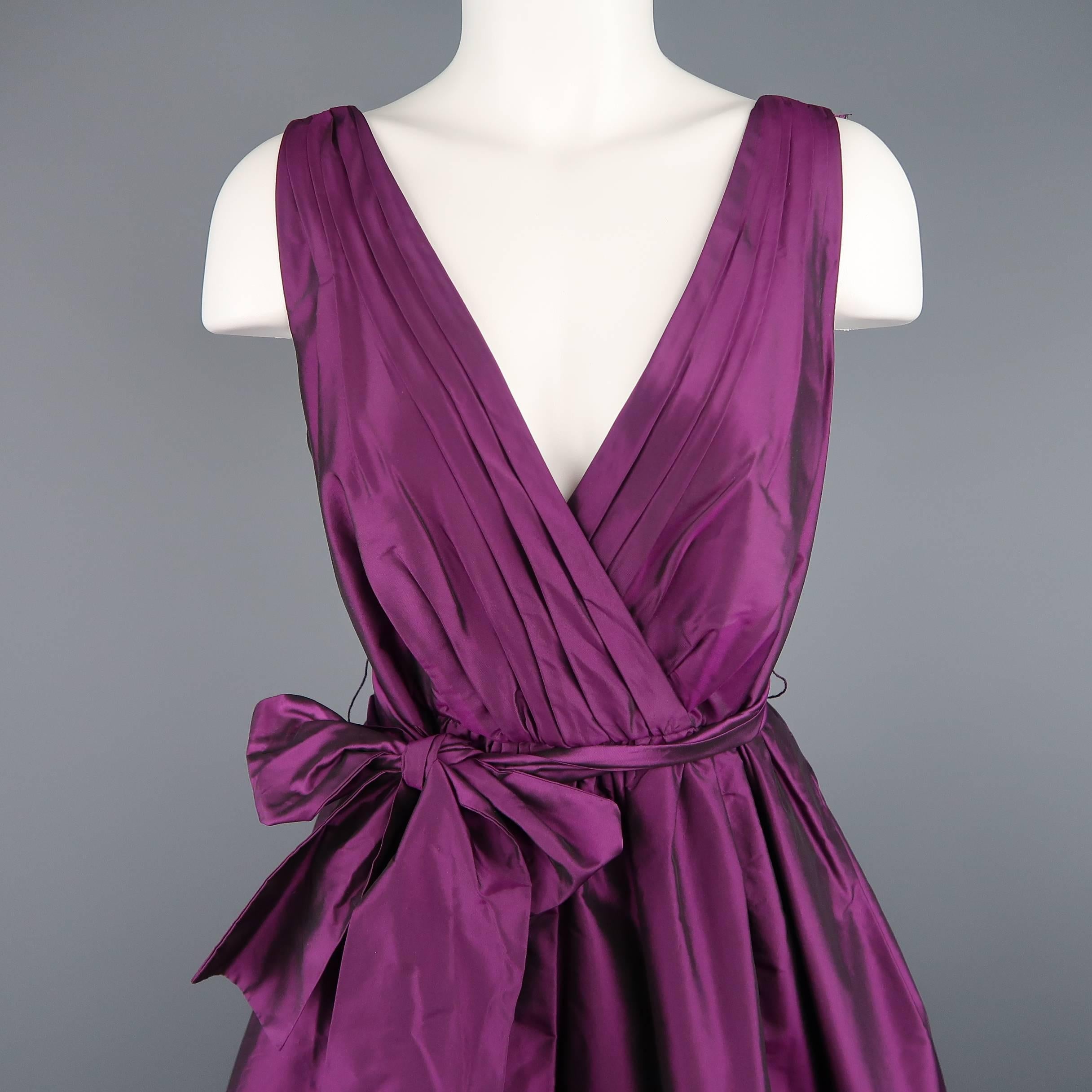 BADGLEY MISCHKA cocktail dress comes in purple silk taffeta with a pleated, wrapped V neck front, sash belt, and full gathered top skirt.
 
New with Tags.
Marked: 6
 
Measurements:
 
Shoulder: 15 in.
Bust: 36 in.
Waist: 28 in.
Hip: 50 in.
Length: 42
