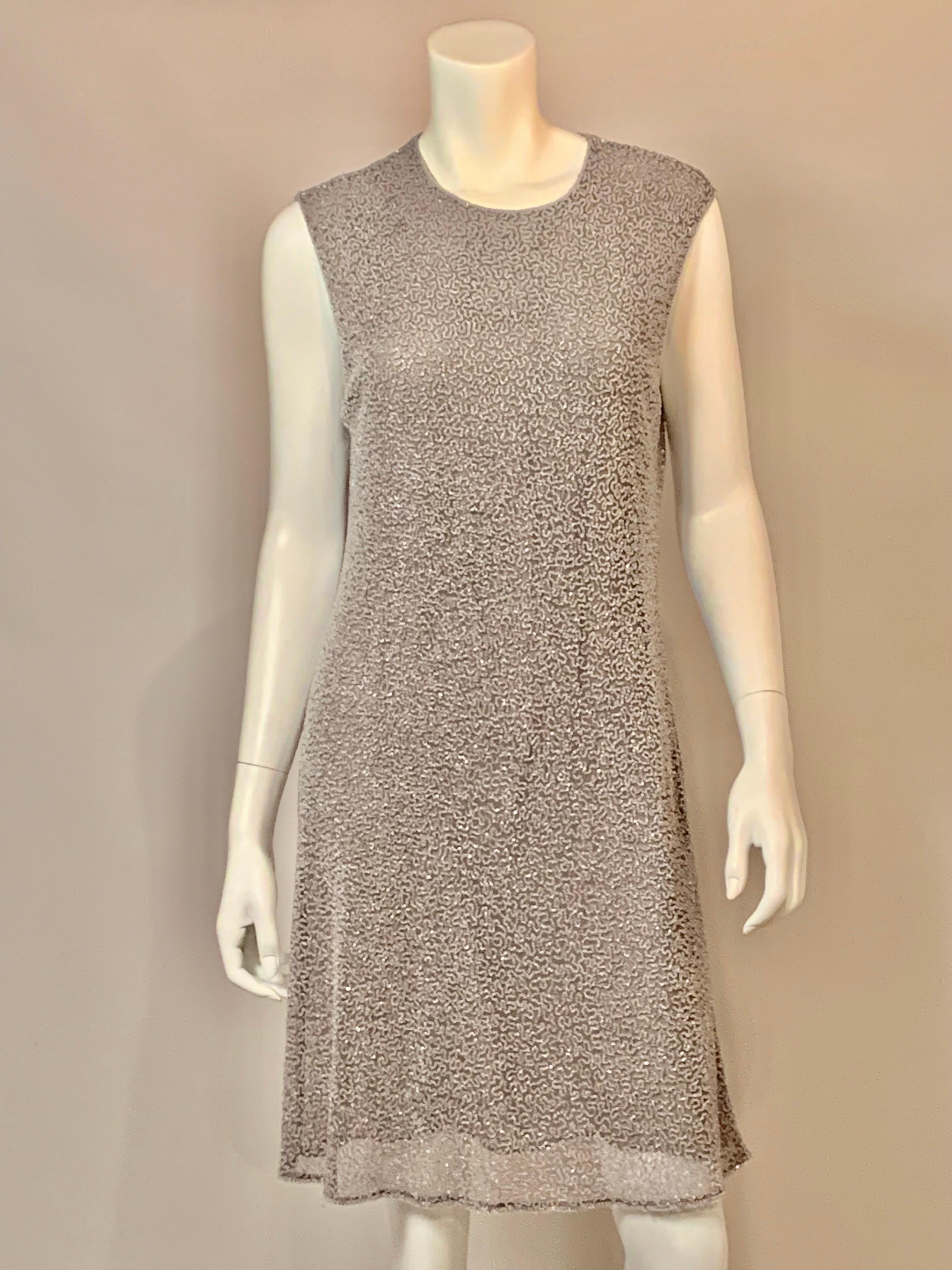 This effortlessly elegant dress from Badgley Mischka is covered with clear beads in a vermicelli pattern on grey tulle.  The dress is lined with a darker grey silk with a center back zipper.  The edges are accented with a double row of beads and the