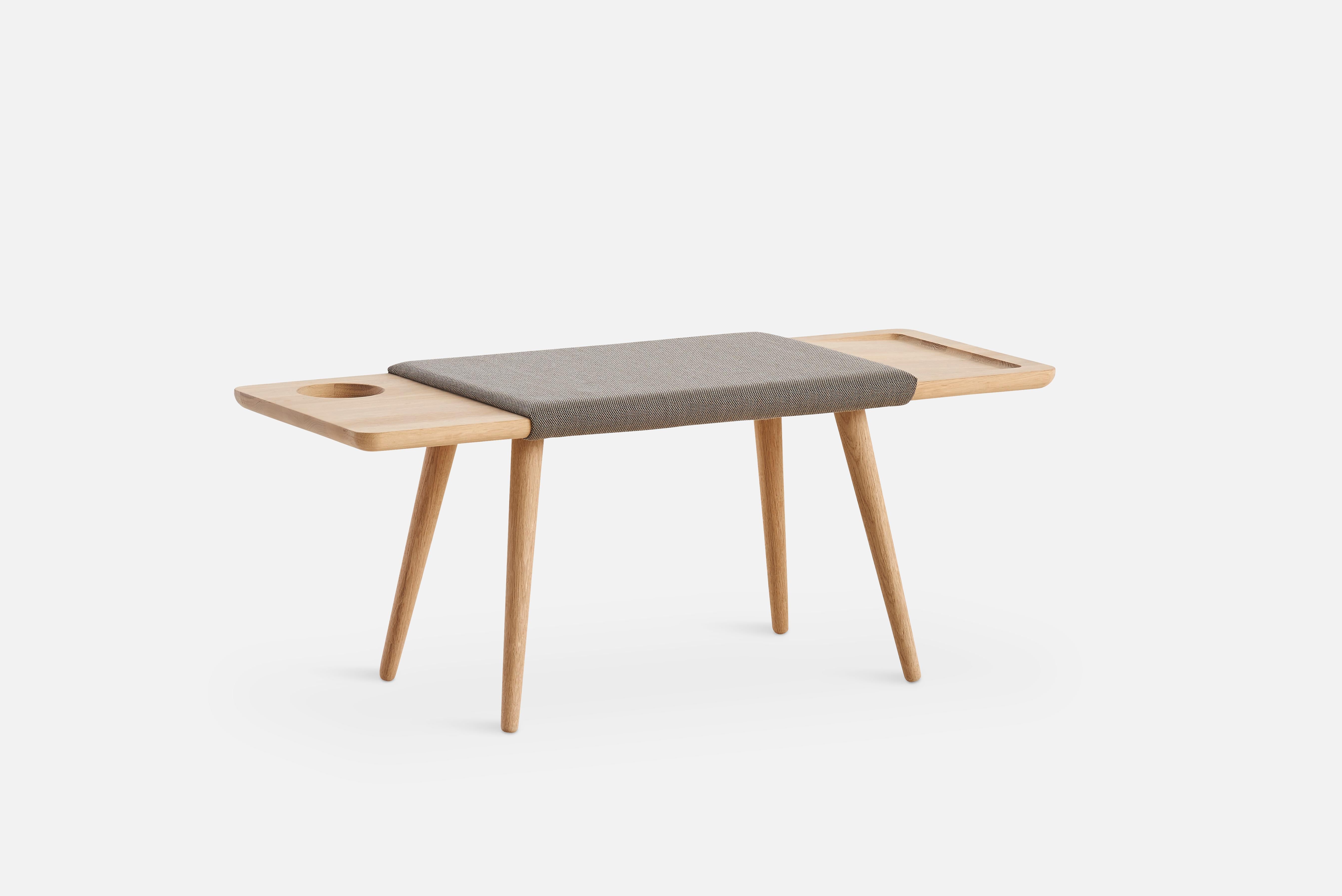 Baenk Bench by Nur Design.
Materials: Solid Oak and Upholstery.
Dimensions: D 42.5 x W 110 x H 45 cm.

The founders, Mia and Torben Koed, decided to put their 30 years of experience into a new project. It was time for a change and a new
