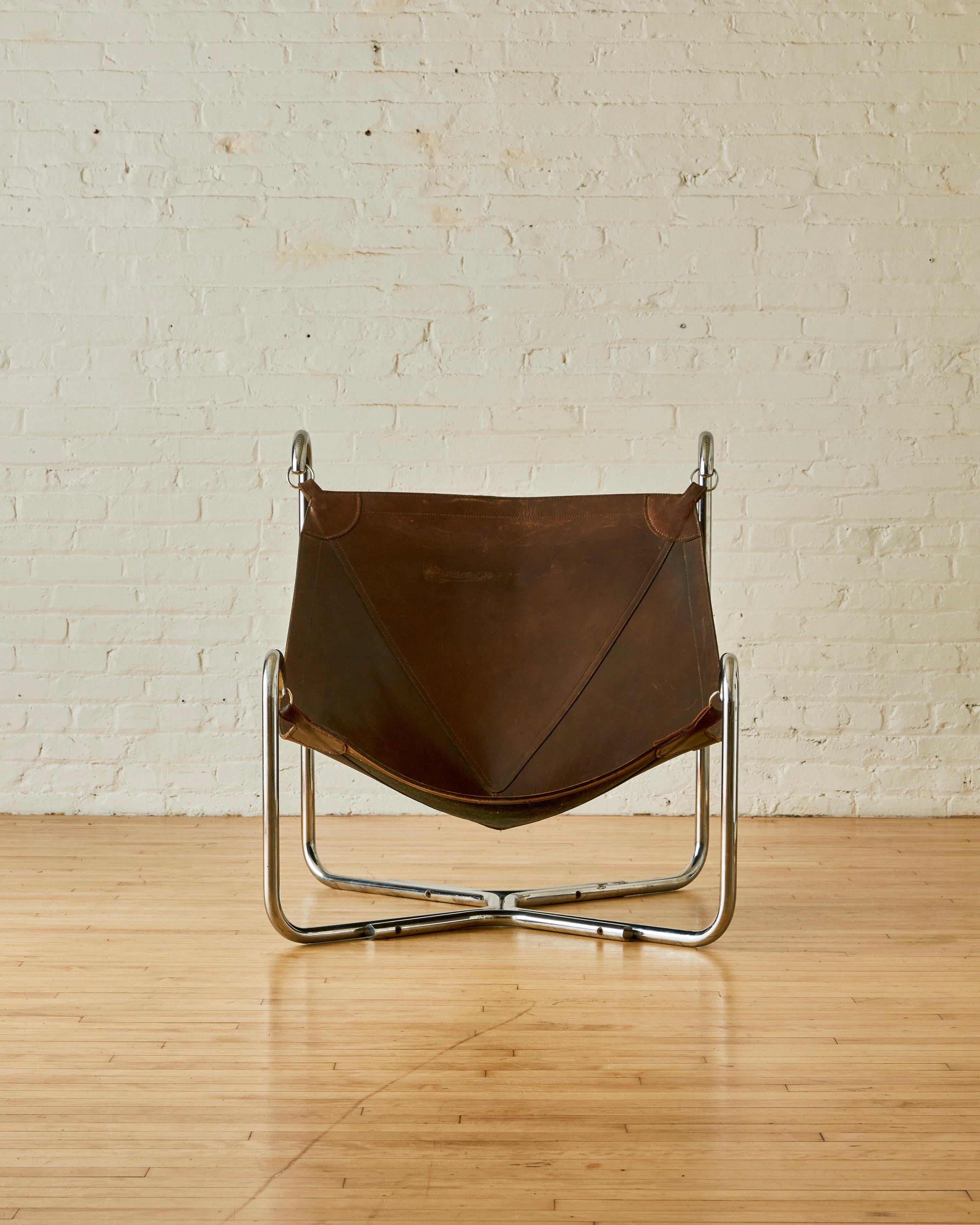 Baffo armchair by Gianni Pareschi and Ezio Didoni for Dam, by Busnelli, features a tubular chromed metal frame. The seat is suspended within the frame and secured by a metal ring connecting the frame to a brown leather seat.

