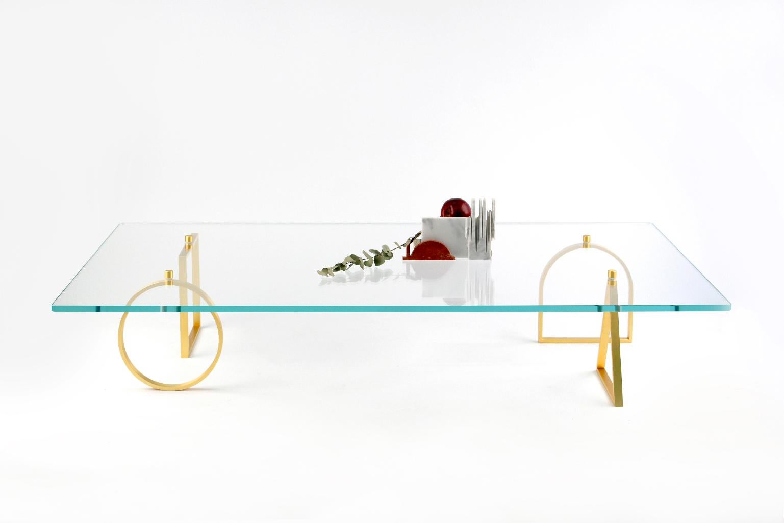 21st Century Bagatto Brass and Glass Contemporary Coffee Table by Ilaria Bianchi is light and ethereal. 
In this coffee table four handmade polished brass geometrical elements supports a 15mm extra clear tempered glass. Four alchemic elements