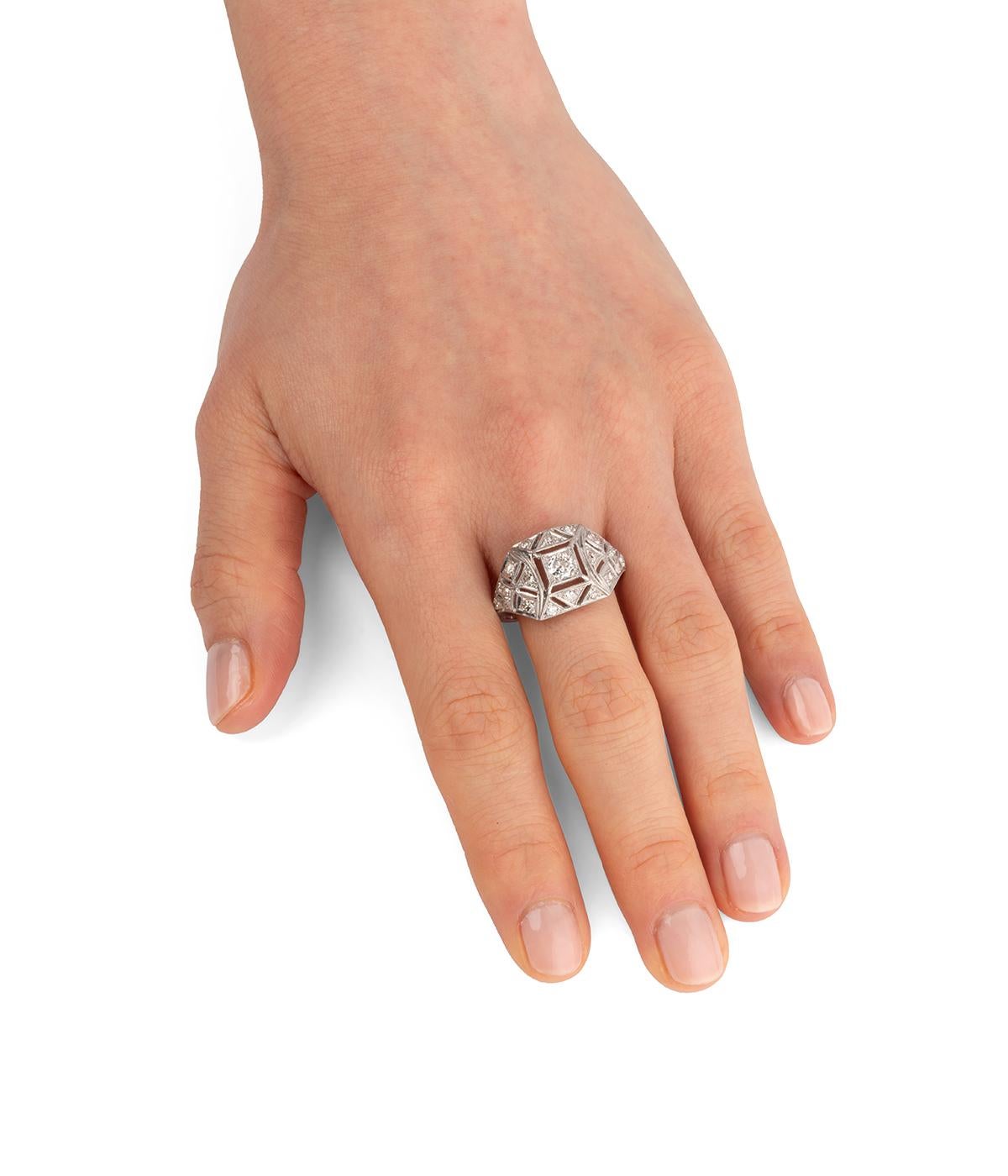 Bague Art déco en platine, décorée de formes géométriques rehaussées de diamants taille 8/8. Le diamant de centre, de taille ancienne, pèse environ 0,2 carat.

Poids total du bijou : 4,4 g.
Taille 55.
Longueur de la bague sur le doigt : 1,3