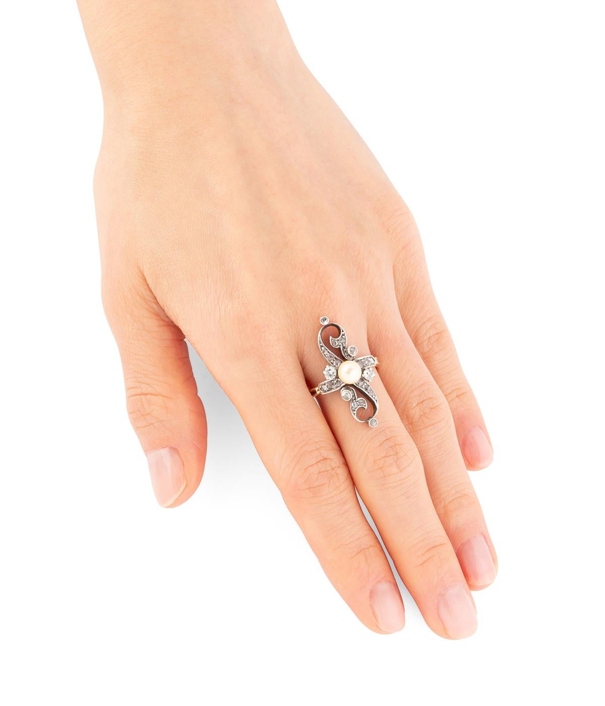 Bague ancienne en or 18 carats (750 millièmes) et argent de la fin du 19ème siècle. Le plateau, de forme navette, est formé de volutes rehaussées de diamants taille rose. Il est centré d'une perle de culture. 

Poids total du bijou : 4,82 g