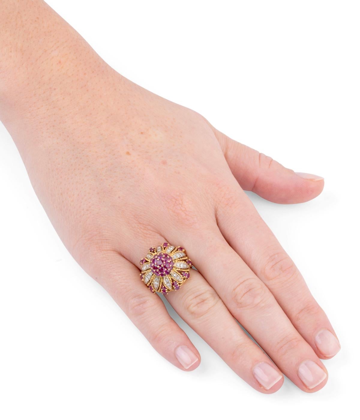 Magnifique bague dôme des années 50. En or 18 carats (750 millièmes), elle représente une fleur dont les pétales sont soulignés de diamants taille 8/8 et le pistil de rubis calibrés.