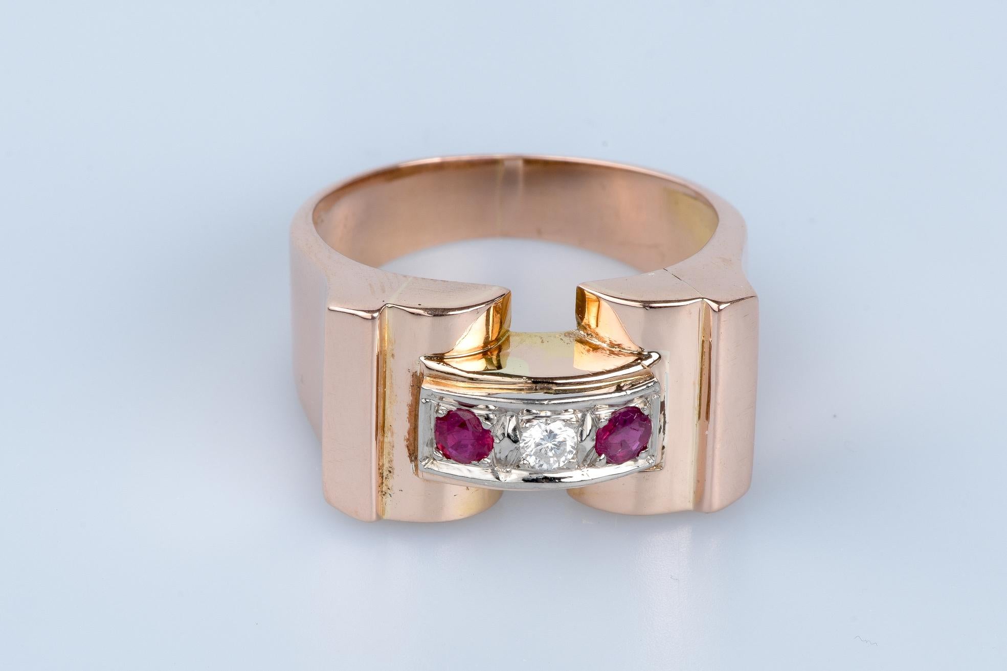 Bague en or rose 18 carats, ornée d'un diamant rond brillant de 0,055 carat et de 2 rubis de 0,024 carat chacun, soit au total 0,048 carat.

Cette pièce exceptionnelle marie avec harmonie la sophistication du design inspiré du style tank à la