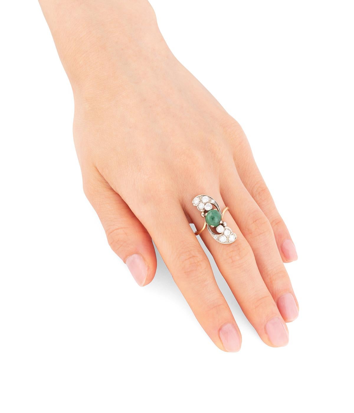 Bague marquise vintage en or 18 carats 750 millièmes) ornée d’un cabochon d'émeraude d'env. 1,85 carats épaulé de 10 diamants taille brillant totalisant env. 1 carat. 

Poids total du bijou : 4,9 g environ.
Taille 51,5.
Longueur de la bague sur le