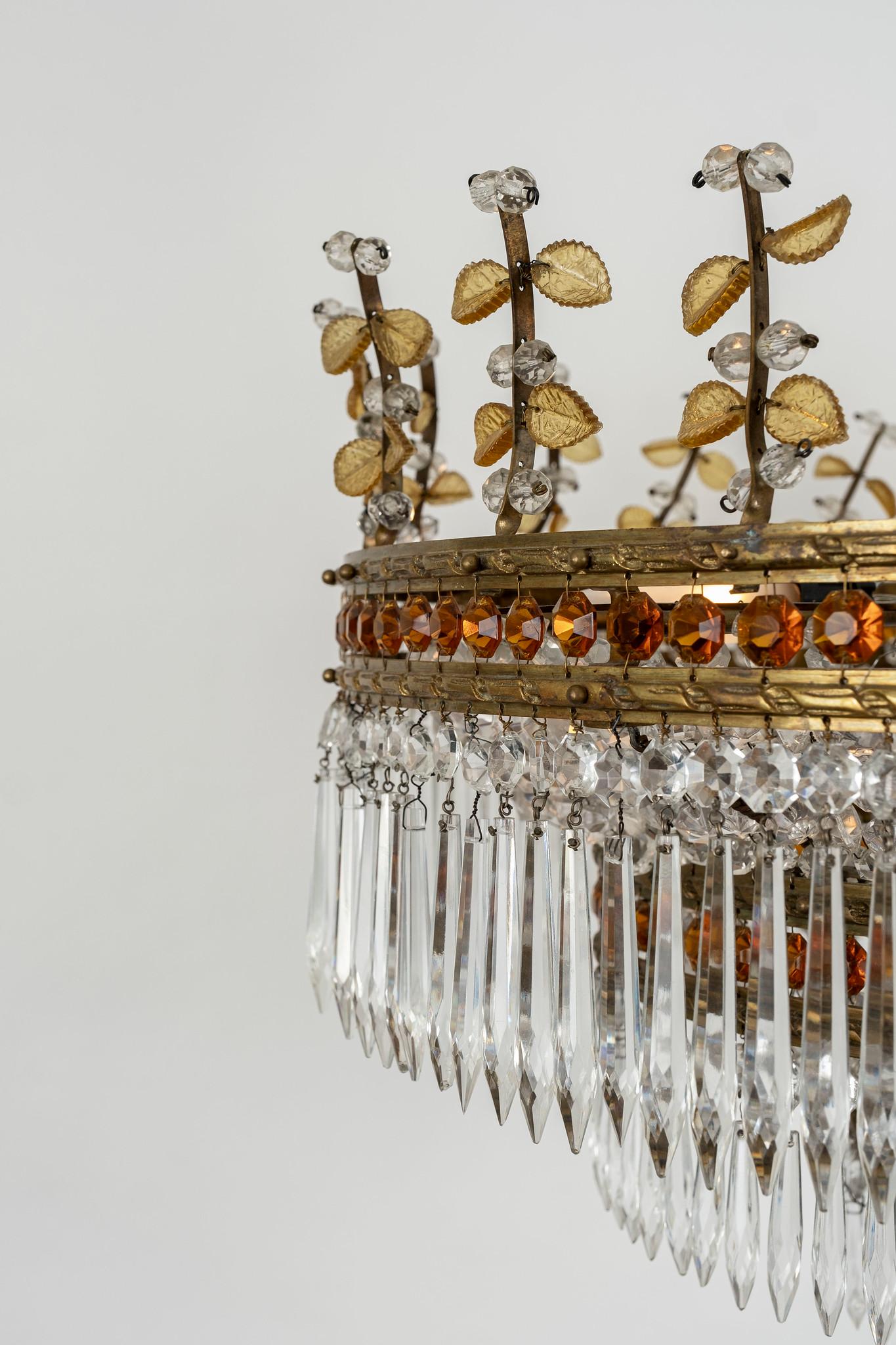 20th century brass and crystal Bagues chandelier. Cascading clear prisms accented with amber colored beads and leaves. 