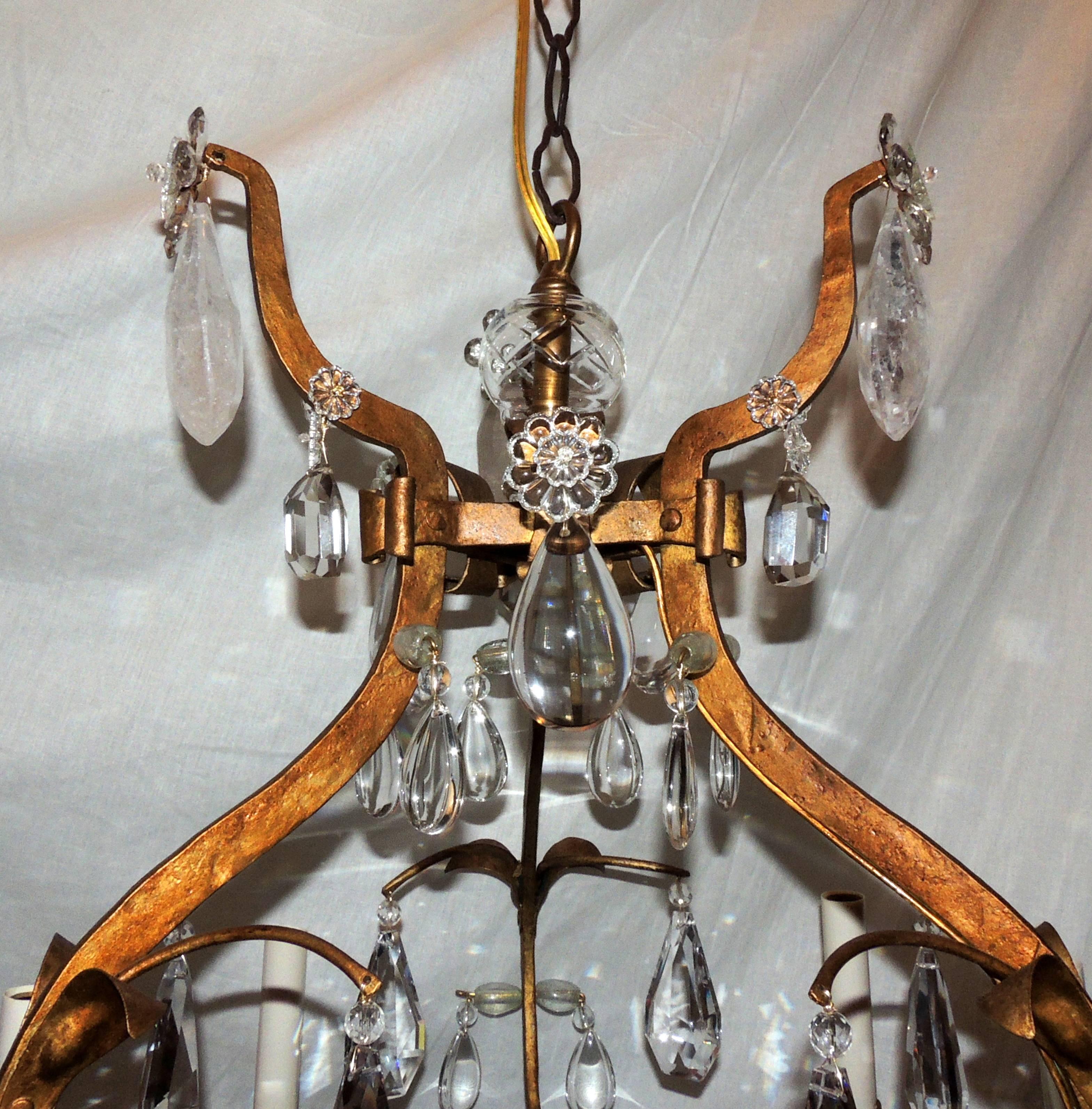A very rare and fine gold gilt iron rock crystal Baguès style six-light chandelier in the Mid-Century Modern design adorned with flowers in a bird cage body.