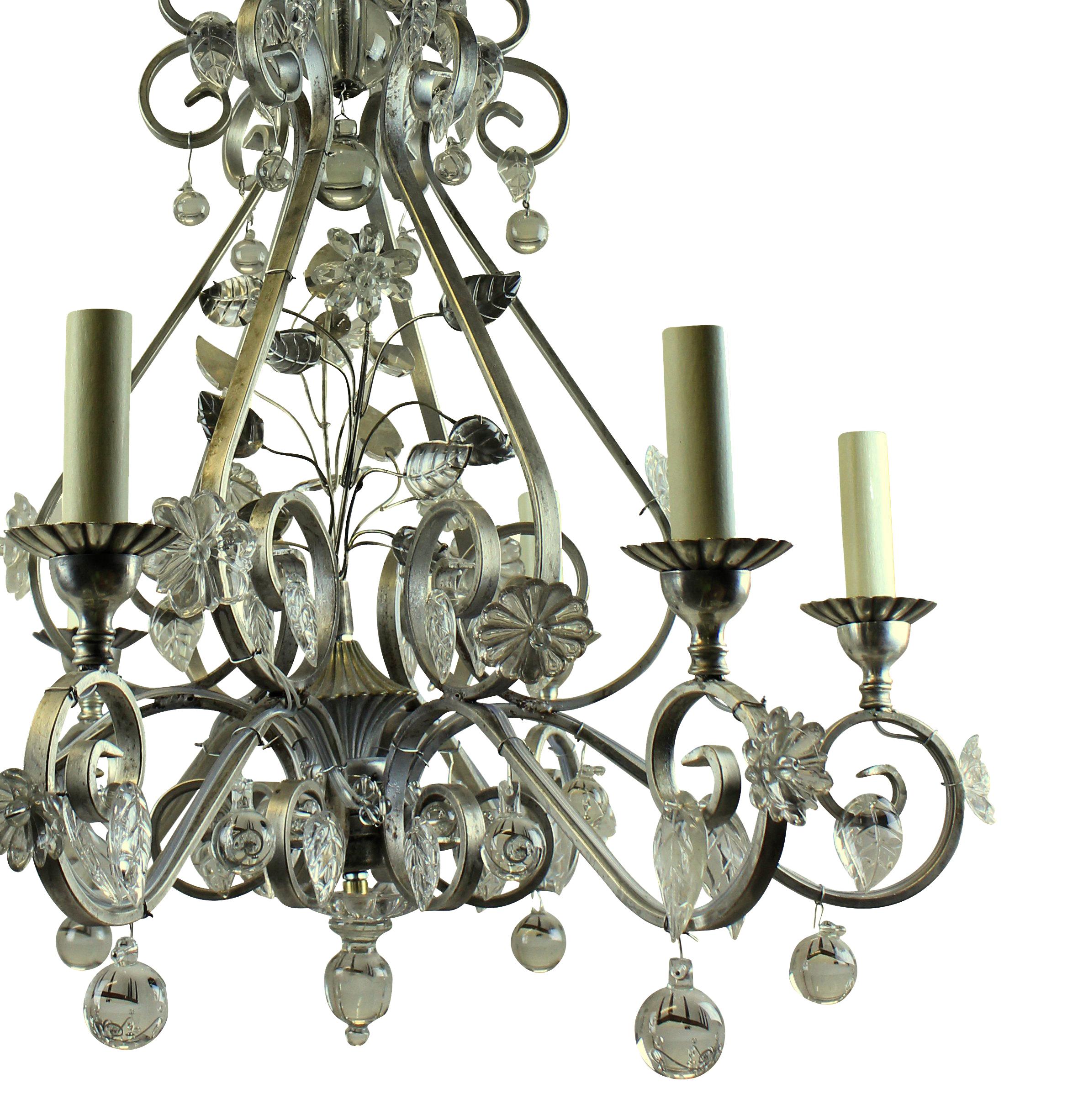 A Baguès style chandelier in silvered metal and hung throughout with glass leaves and flowers.
