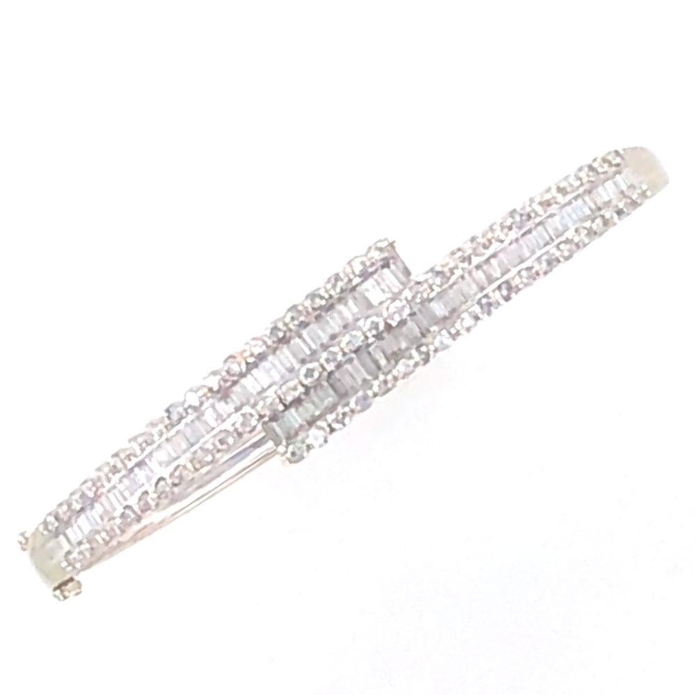 Baguette and round brilliant cut diamonds sparkle in the white gold bangle bracelet. Baguette cut diamonds are set north to south and are surrounded by round brilliant cut diamonds that equal 2.25 carat total weight. The diamonds are graded H-I