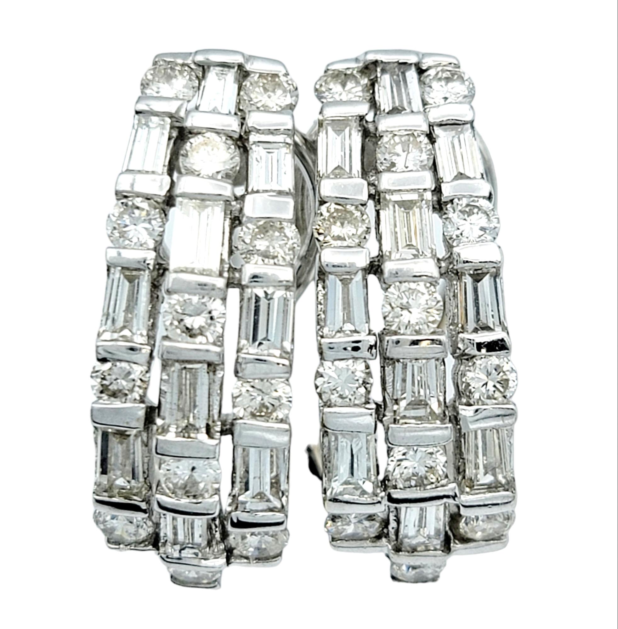 These gorgeous J-hoop diamond earrings are a dazzling testament to both modern sophistication and timeless elegance. Their design is both intricate and bold, creating a striking accessory that adds a touch of luxury to any ensemble. 

The