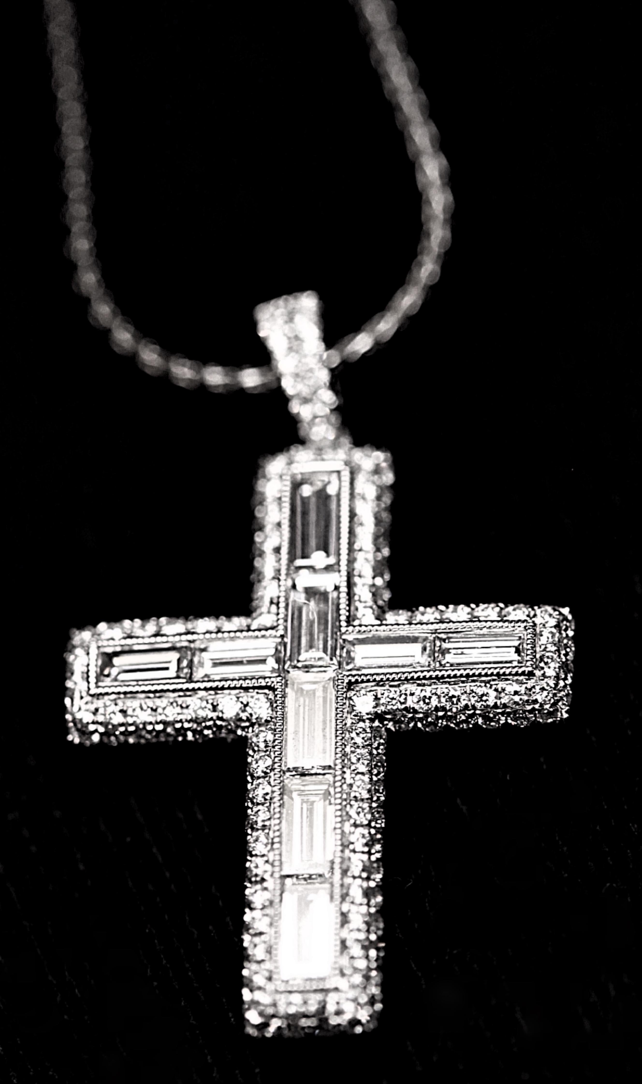 This unique and beautiful 18 karat white gold diamond cross has 2.17 carats total weight of fine white , VVS-VS diamonds.  The diamonds are baguette cut and round brilliant cut and the designer is House of Baguettes.  The cross has beading along the