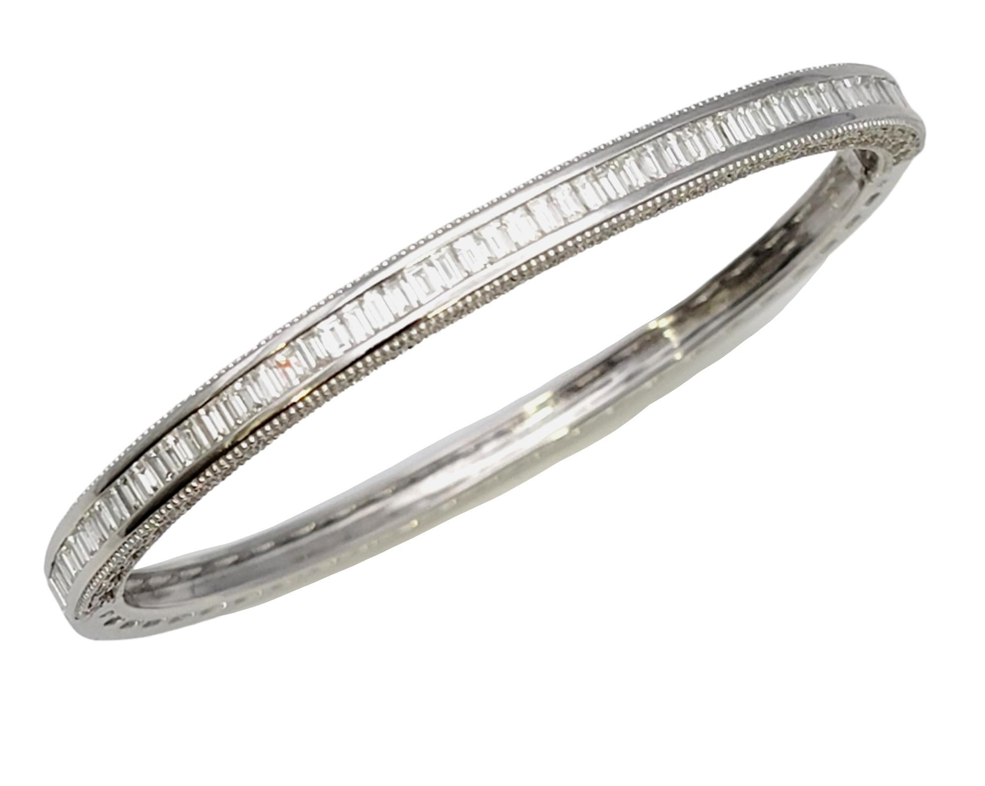 Sleek and sparkly diamond bangle bracelet in polished 18 karat white gold. This elegant bracelet absolutely shines on the wrist, glittering from every angle. Icy white baguette diamonds are channel set along the top half of the bracelet, set very