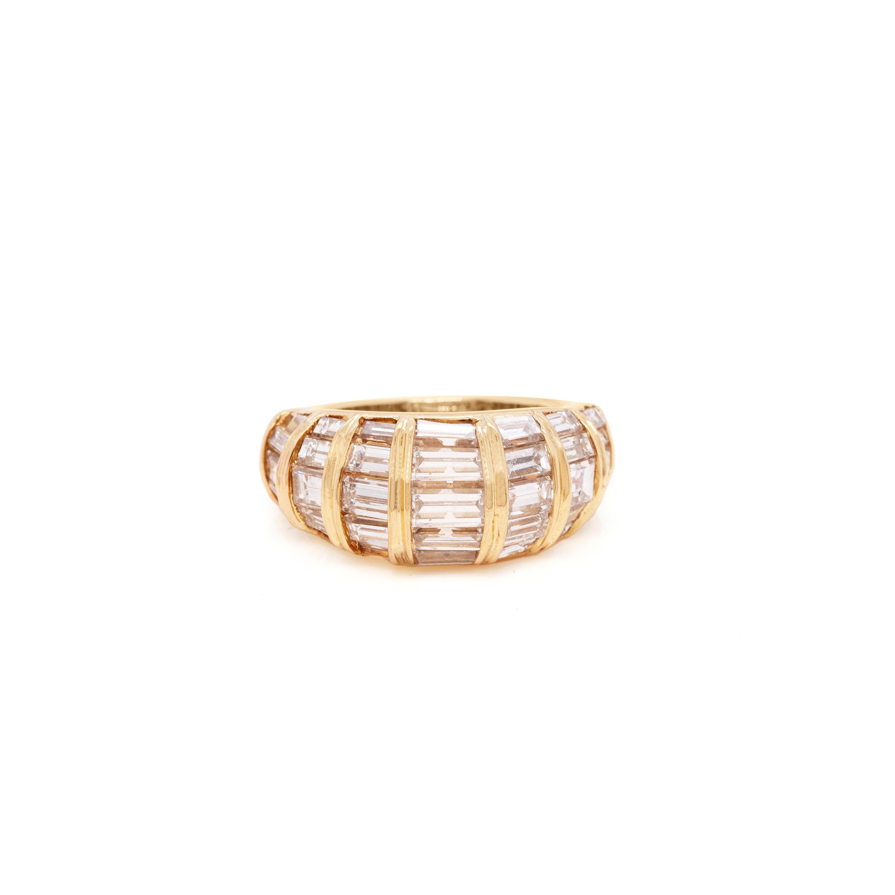 This gorgeous 18 carat yellow gold bombé cluster ring is crafted with seven rows of channel set baguette cut diamonds each, boasting a remarkable approximate total weight of 5.00 carats, all constructed into a fluid domed design. The ring tapers
