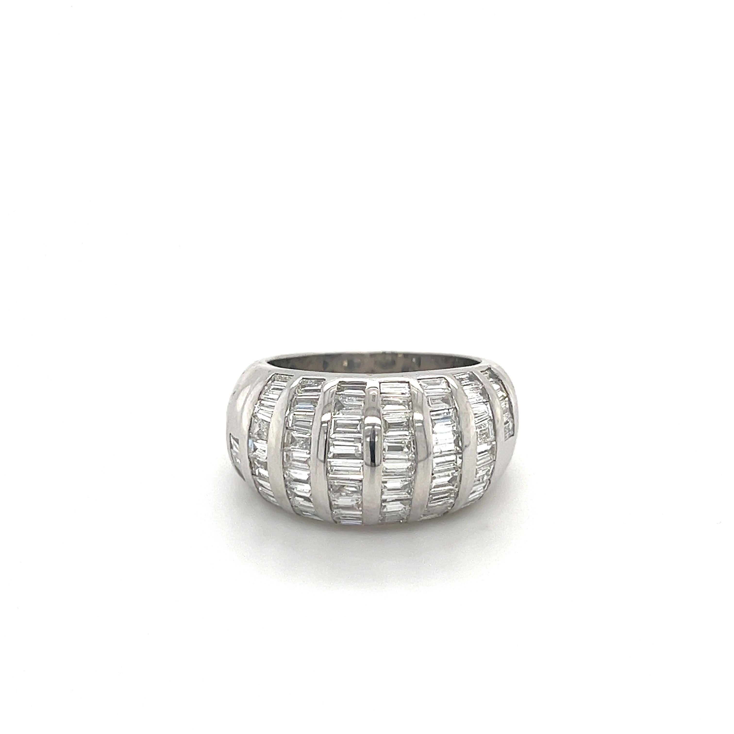 Baguette-cut natural diamond cluster dome ring set in a smooth 18 karat solid white gold setting. Gallery back setting for a comfortable and breathable fit on the finger. 

The diamonds are white, eye-clean stones. Tension set with a white gold half