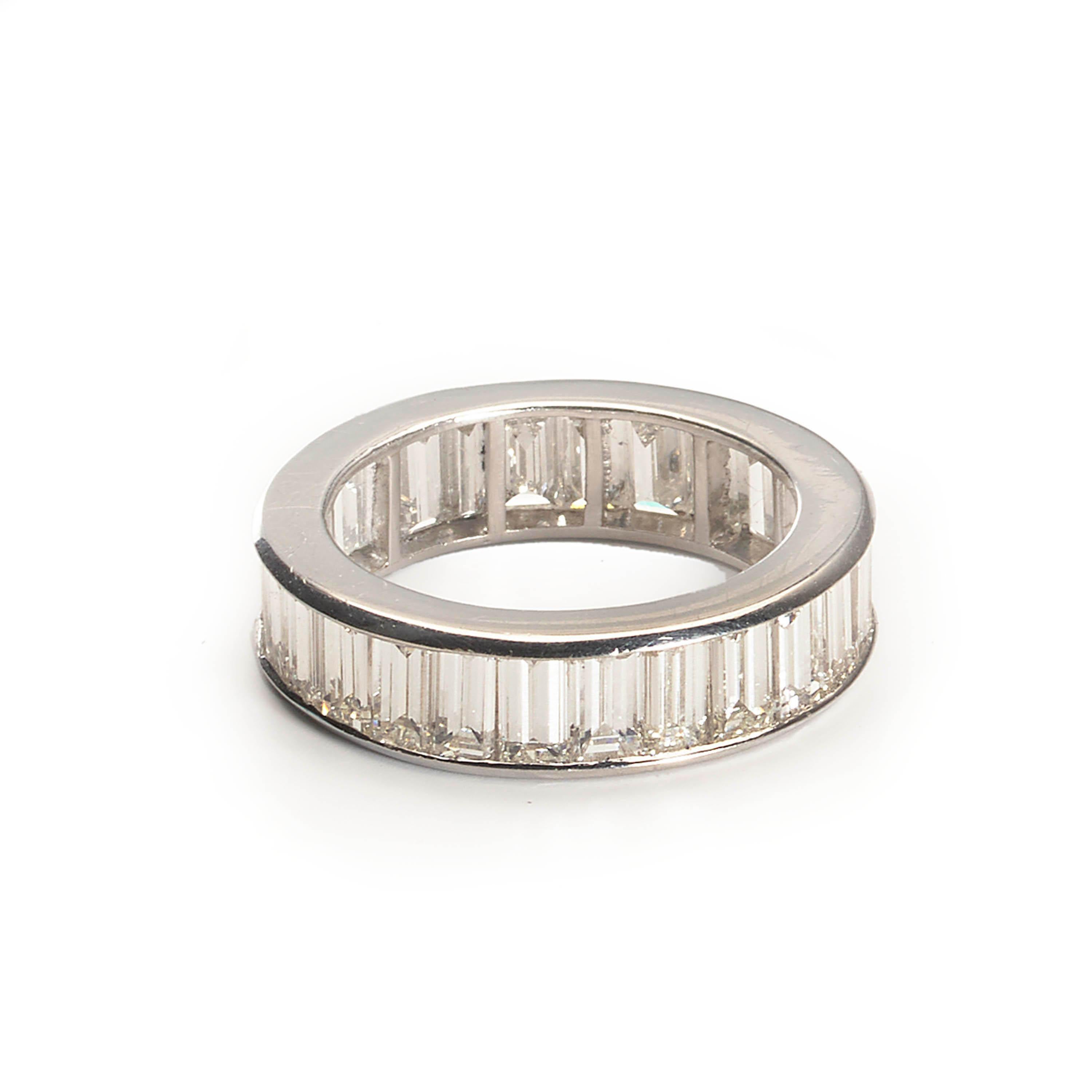 A modern full eternity ring, set with twenty seven baguette-cut diamonds, weighing an estimated total of 6.00 carats, channel set and mounted in platinum.