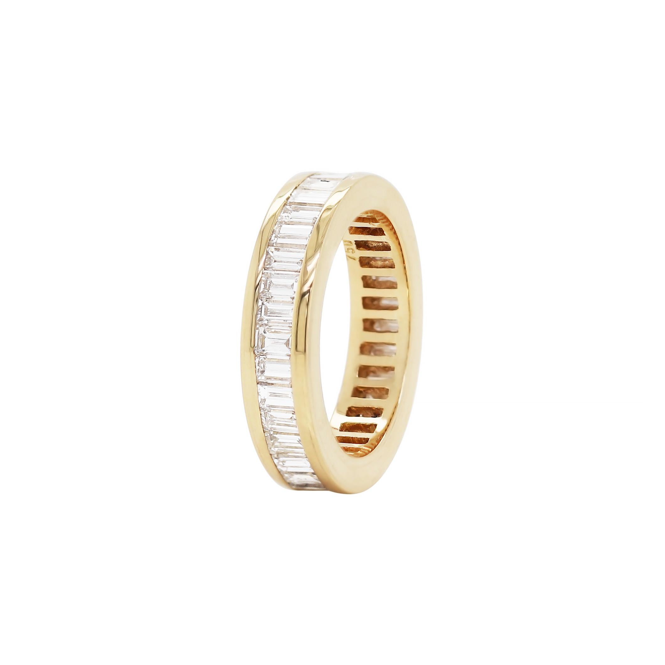 Beautiful eternity ring channel set with 36 fine quality baguette cut diamonds with a total approximate weight of 3.00ct, all mounted in 18ct yellow gold. The ring weighs 7.6gr and measures 5.2mm. Stamped 750. UK finger size ‘N’.
