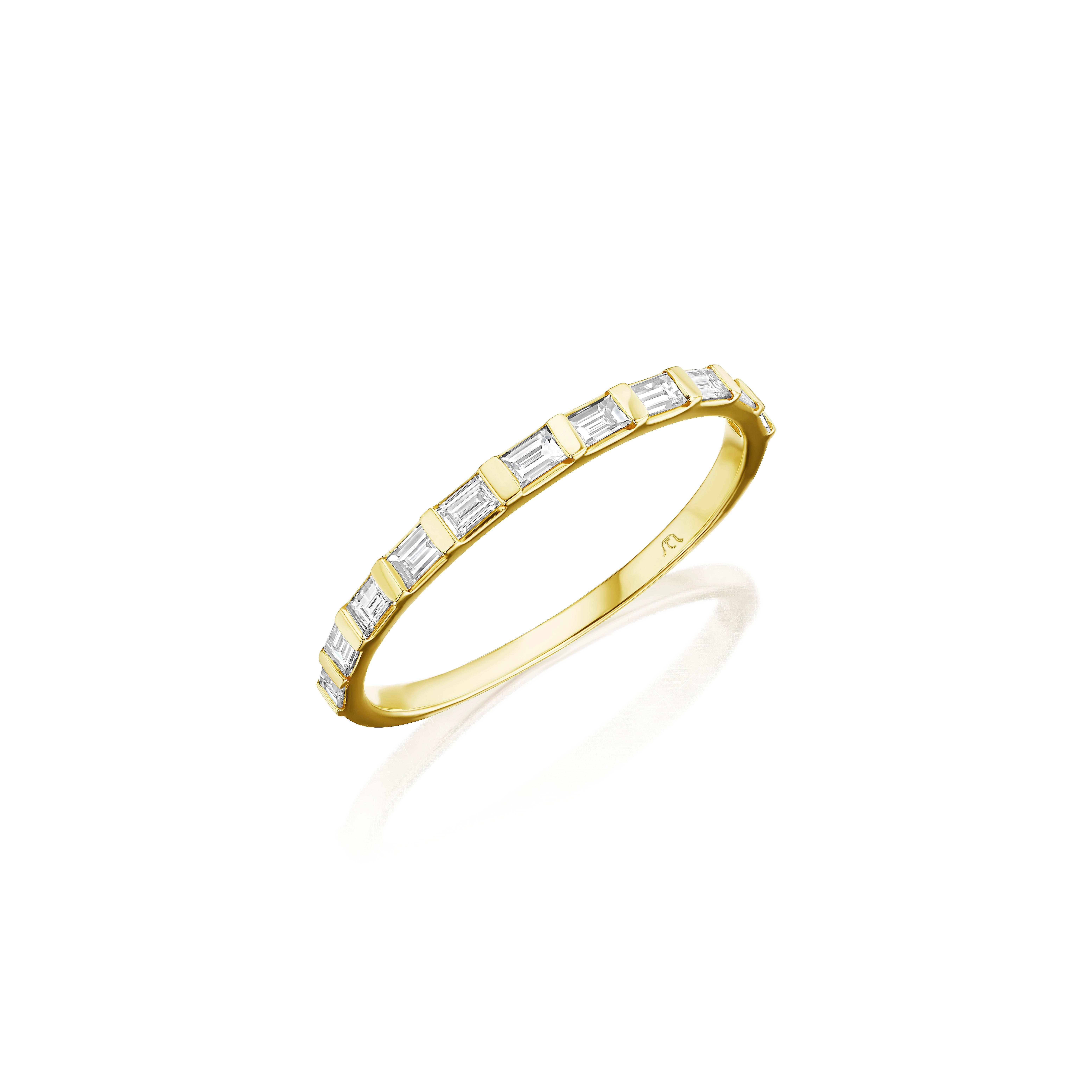• Crafted in 14KT Yellow Gold, this band is made with 11 baguette cut diamonds. The diamonds are set half way down the band and are secured in a bar setting. The band has a combining total weight of approximately 0.39 carats. 
Worn beautifully on