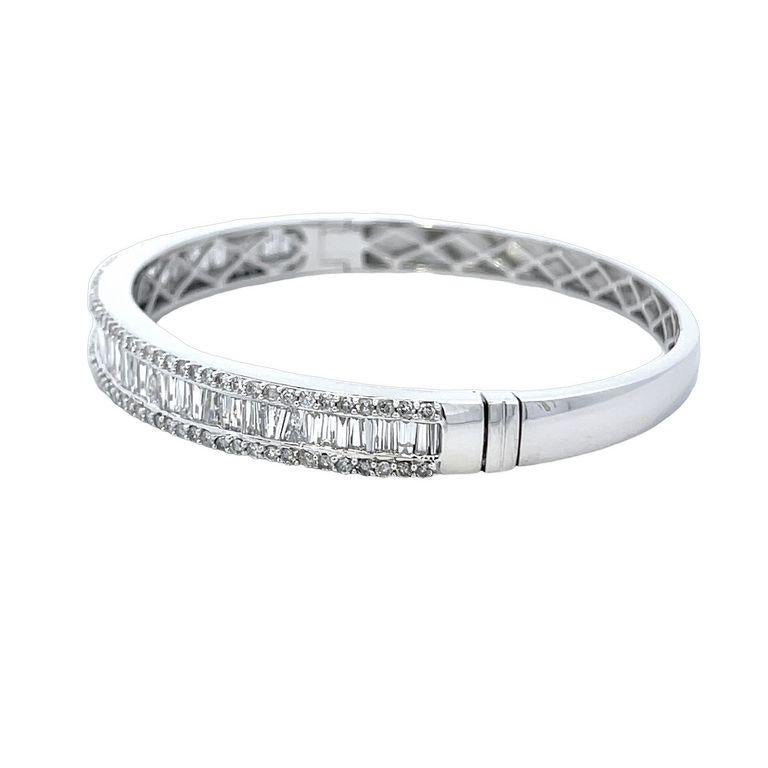 We are thrilled to introduce you to our stunning Sparkle Baguette Diamond Bangle! This exquisite piece has been crafted with the utmost care and attention to detail, featuring a row of shimmering baguettes and round diamonds arranged in a