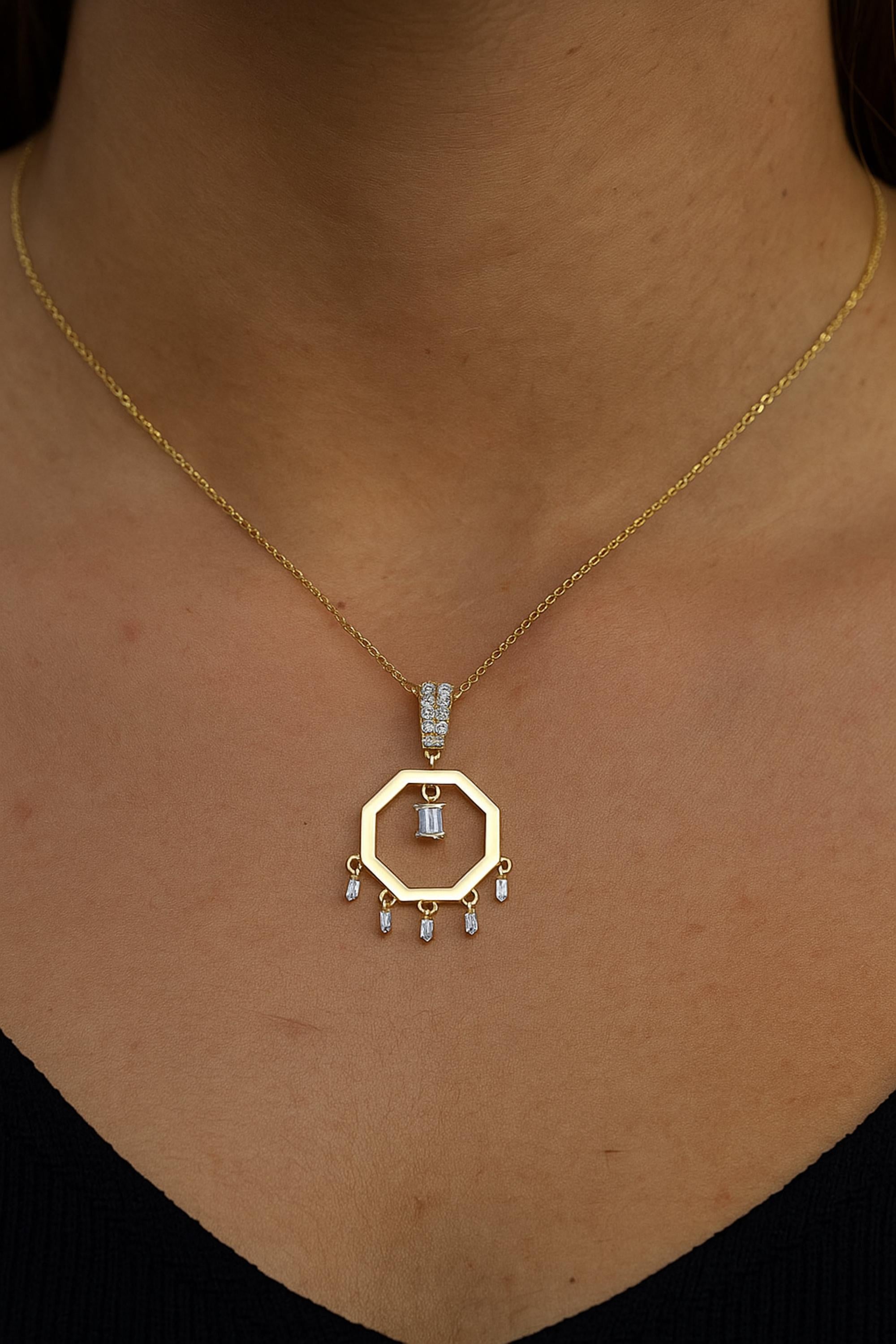 Ajoutez une touche d'élégance et de sophistication à votre collection de bijoux avec cet exquis collier pendentif à breloques en diamant baguette. Réalisée à la main avec un savoir-faire méticuleux, cette pièce de haute joaillerie présente une