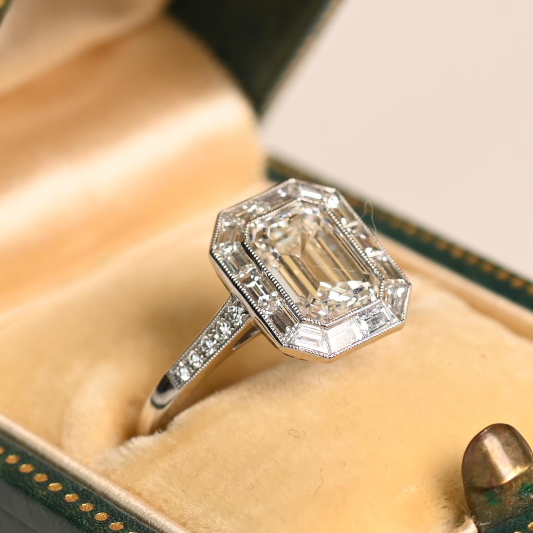 Este exquisito anillo luce un diamante talla esmeralda engastado en bisel que pesa aproximadamente 1,8 quilates. Certificada por el GIA, la piedra central tiene un grado de color H y una claridad VS2, lo que garantiza un brillo y una pureza