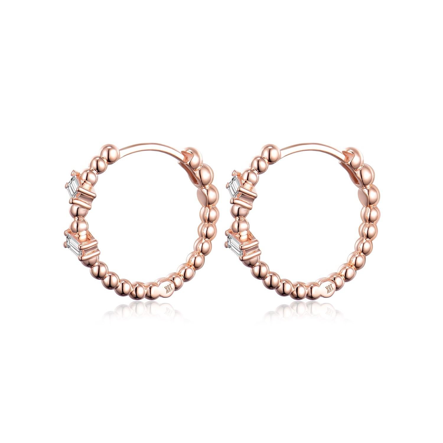 The Baguette Diamond Hoop Earrings in 18 Karat Rose Gold are a stylish and versatile pair of earrings that effortlessly combine elegance with everyday wearability. Crafted with care, these hoop earrings feature a unique design with bead accents and