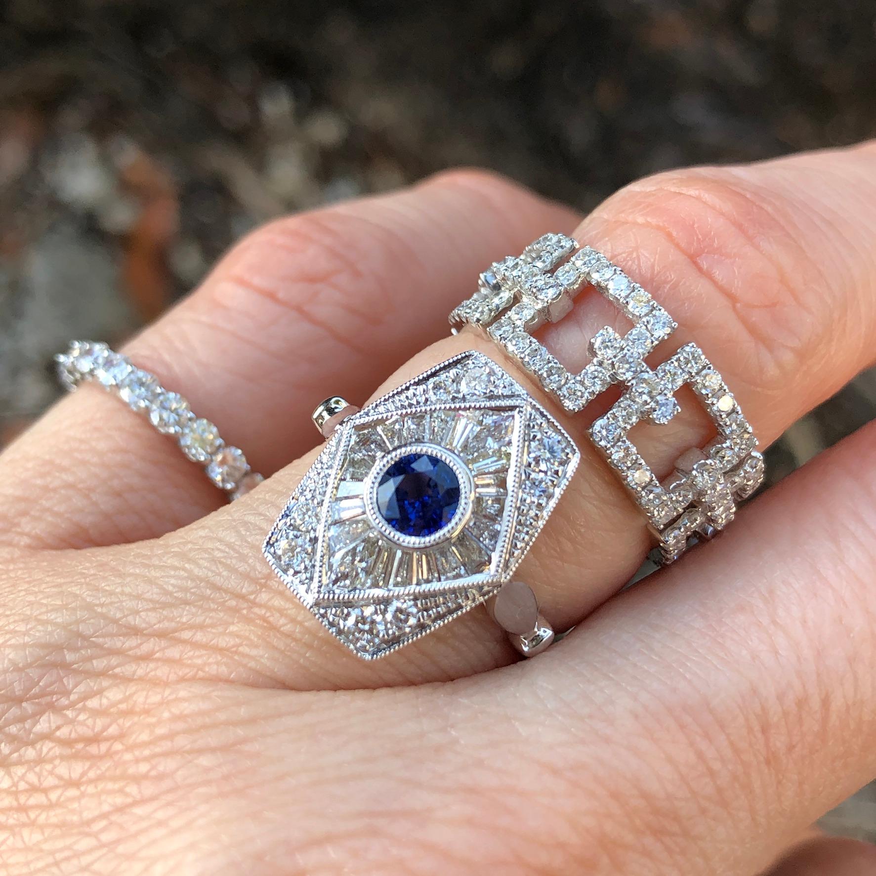 Sure to be a family heirloom! 

18K white gold ring with baguette diamond precisely cut to envelope the center sapphire. The total diamond in tapered baguettes is .48 carat total weight and features an additional .38 carats in pave diamonds at the