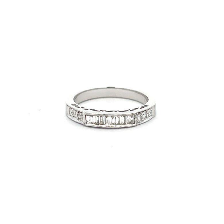 Dieser atemberaubende Ring ist ein Meisterwerk aus zeitloser Eleganz und zeitgenössischem Stil. Das verschlungene Design zeichnet sich durch eine Reihe von runden und Baguette-Diamanten aus, von denen jeder eine atemberaubende F-Farbe und