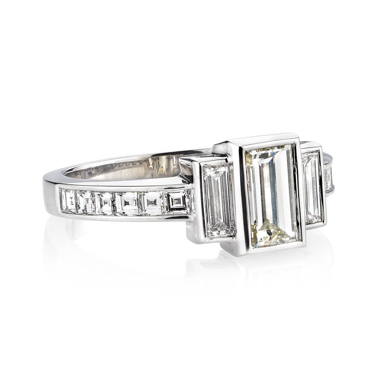 0.88ct L/VS1 GIA certified emerald cut diamond with 0.72ctw mixed cut accent diamonds set in a handcrafted platinum mounting.

