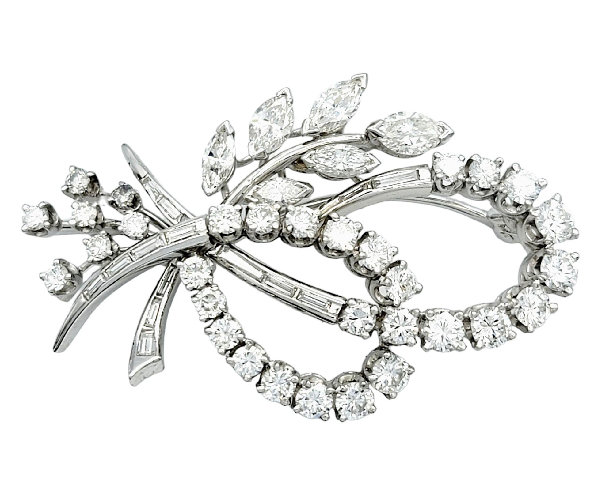 This enchanting and versatile diamond piece set in exquisite platinum is a work of art. Crafted in a captivating branch and leaf design, the piece features a harmonious blend of marquise, baguette, and round diamonds. The intricate arrangement of