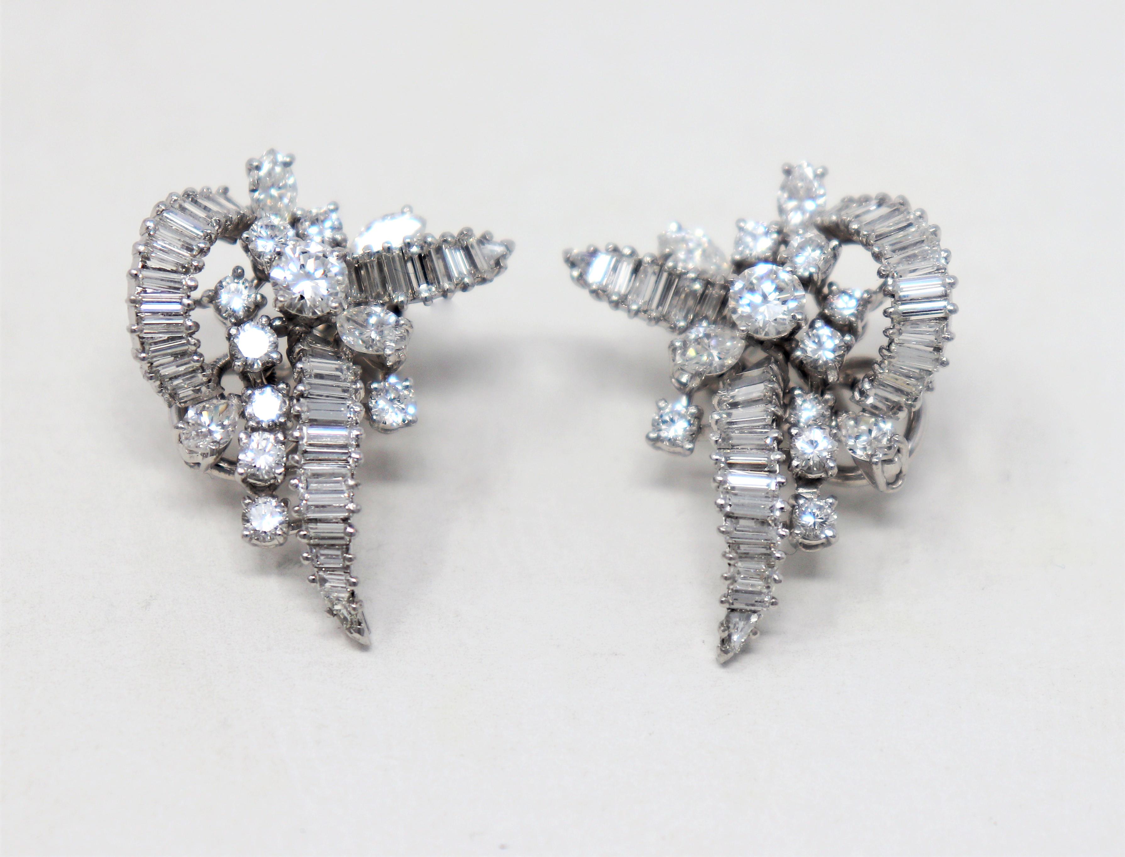 These stunningly sparkly diamond earrings are an incredible sight to see. The exquisite earrings feature a unique arrangement of assorted icy white diamonds set in polished platinum. The intricate swirls and curves of the design reflect the light,