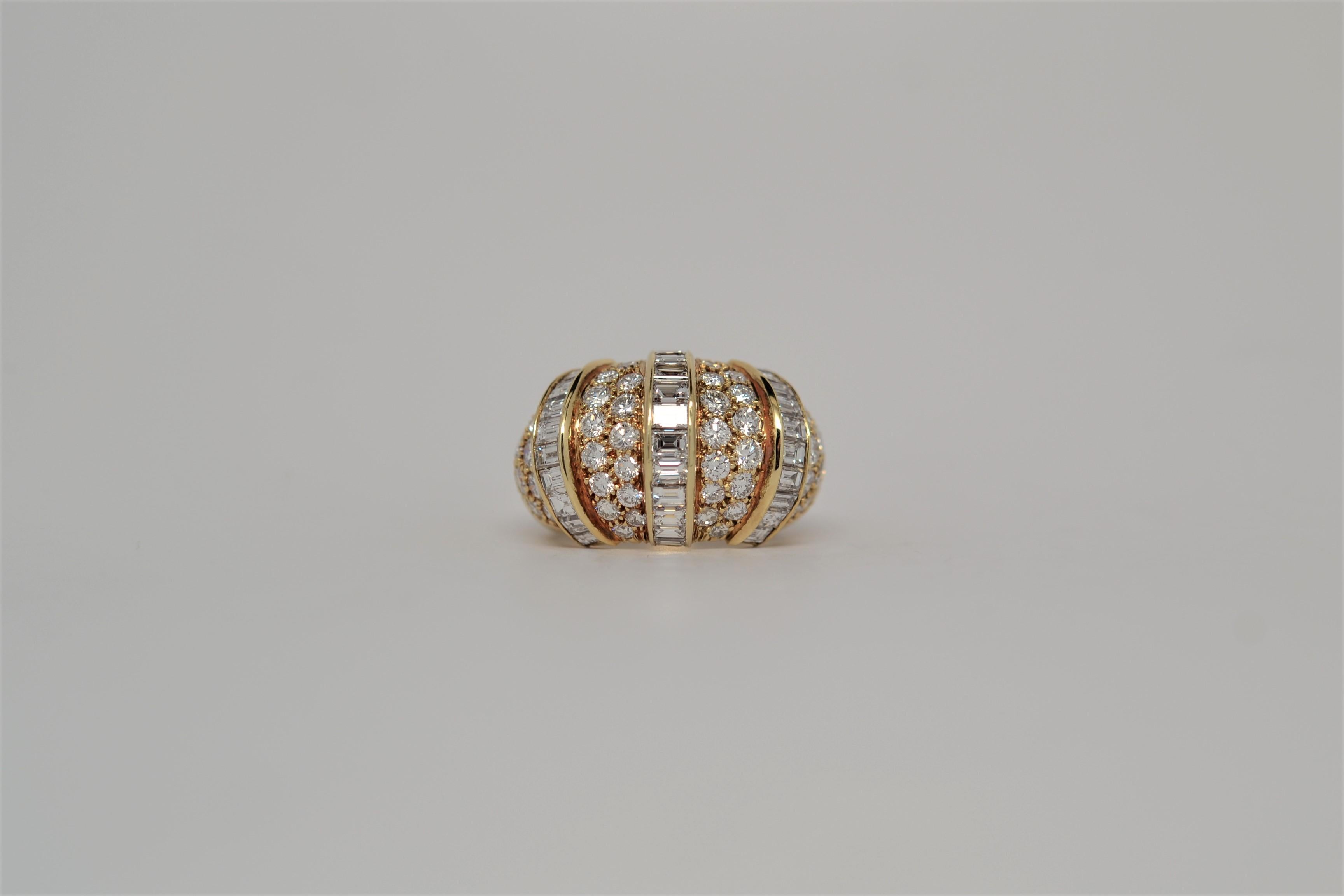 This custom and beautifully crafted ring is set in 18K Yellow Gold with Baguette Diamonds and Round Brilliant Cut Diamonds. Three rows of Baguette Diamonds are channel set in and East to West layout. 
Thirty one Baguette Diamonds weigh 2.56ct.