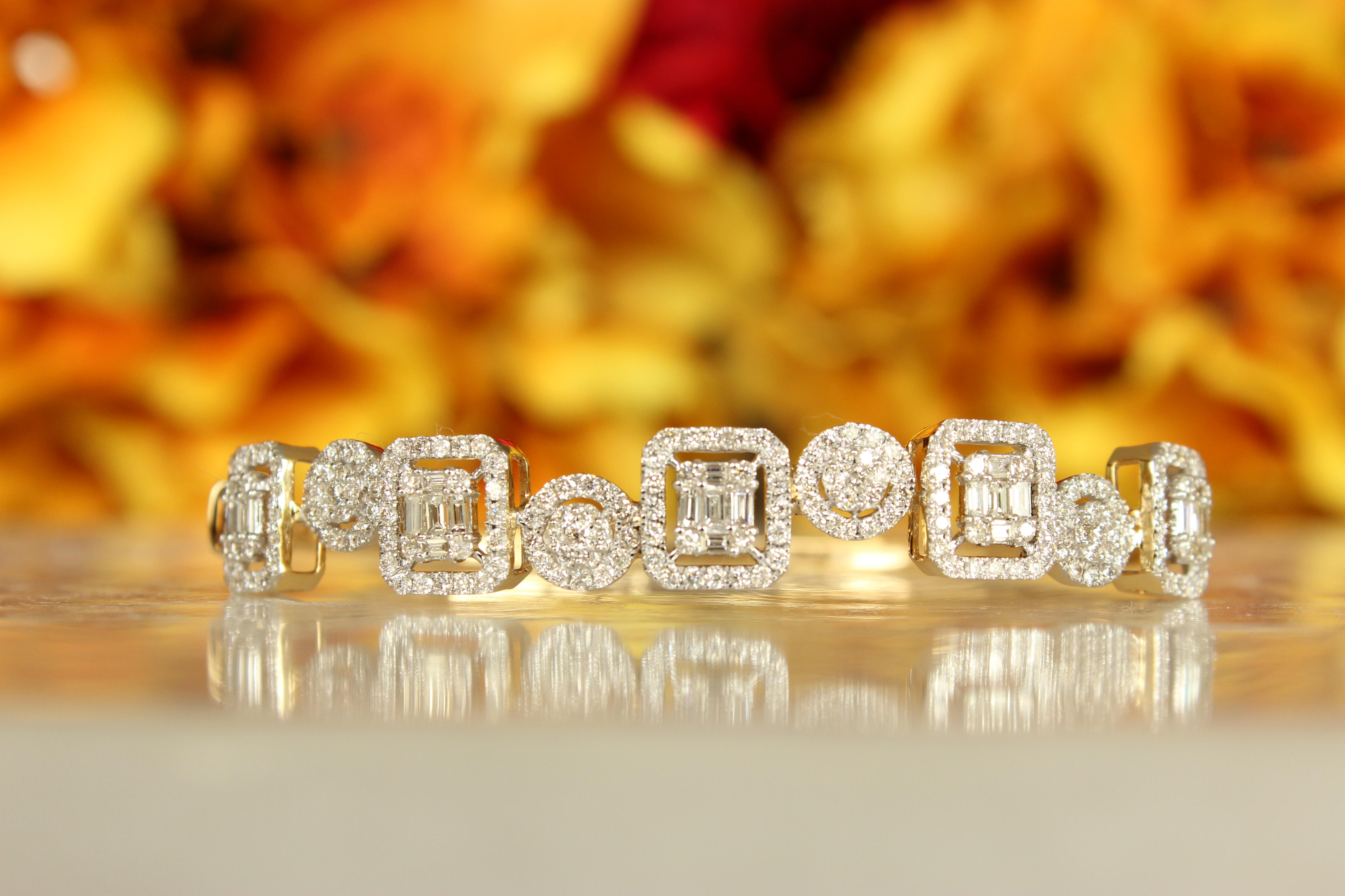 The Baguette & Round Cut Diamond Halo Bracelet is a series of exquisitely cut diamonds, possibly of the baguettes and rounds, surrounded by halos of smaller, round-cut diamonds. The setting is in a precious metal gold. Each link appears meticulously