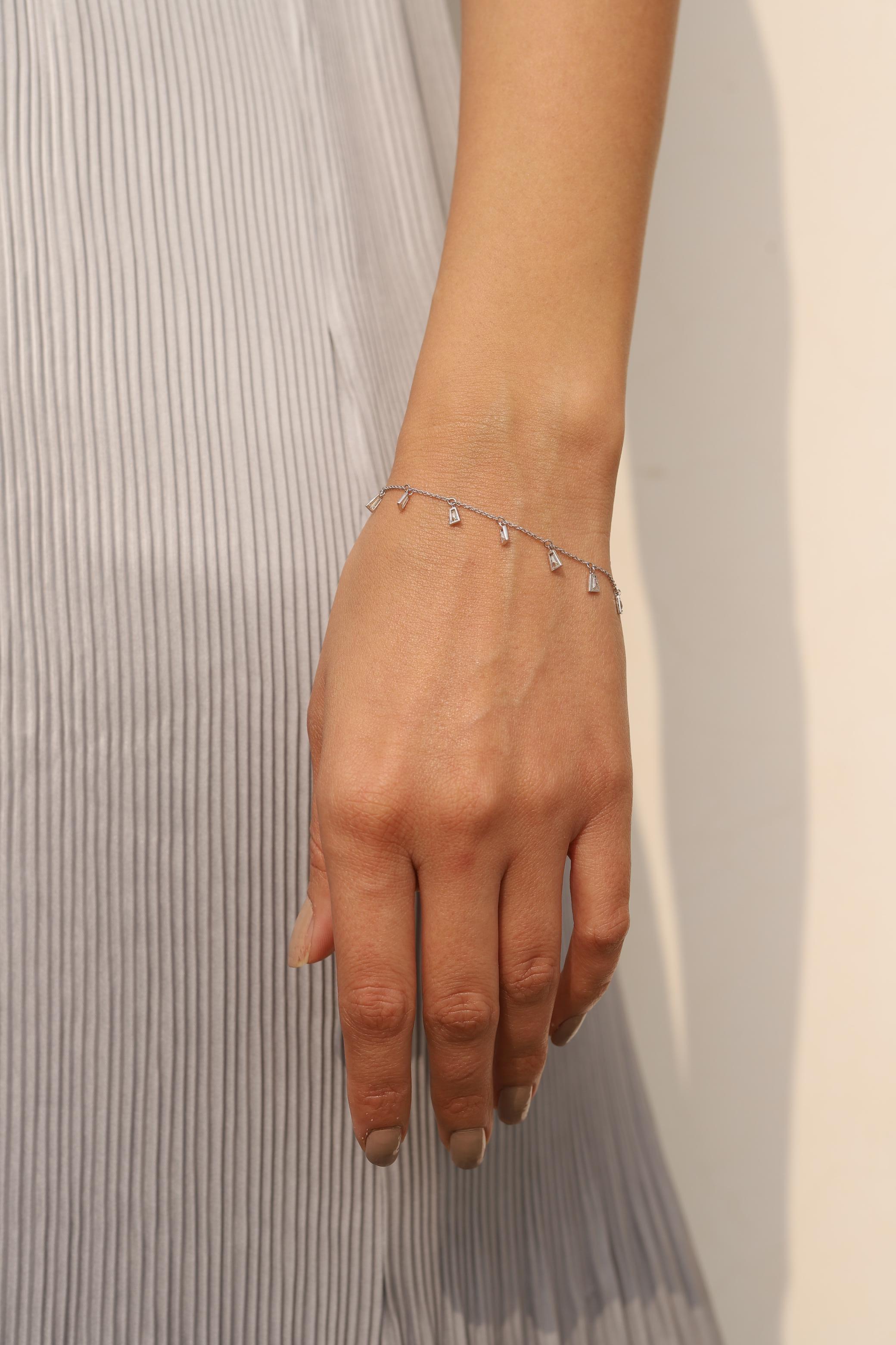 Dieses Baguette-Diamant-Charm-Armband aus 18 Karat Gold präsentiert funkelnde natürliche Diamanten mit einem Gewicht von 0,94 Karat. 
Der April-Geburtsstein Diamant bringt Liebe, Ruhm, Erfolg und Wohlstand.
Das Design mit Diamanten im