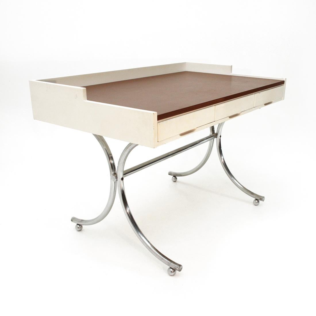 Desk produced by Adriasteia in the 1960s on a project by Annig Sarian.
Base in chromed metal.
Top in white varnished wood with three drawers and top surface covered in vinyl leather.
Good general conditions, some signs and traces of rust due to