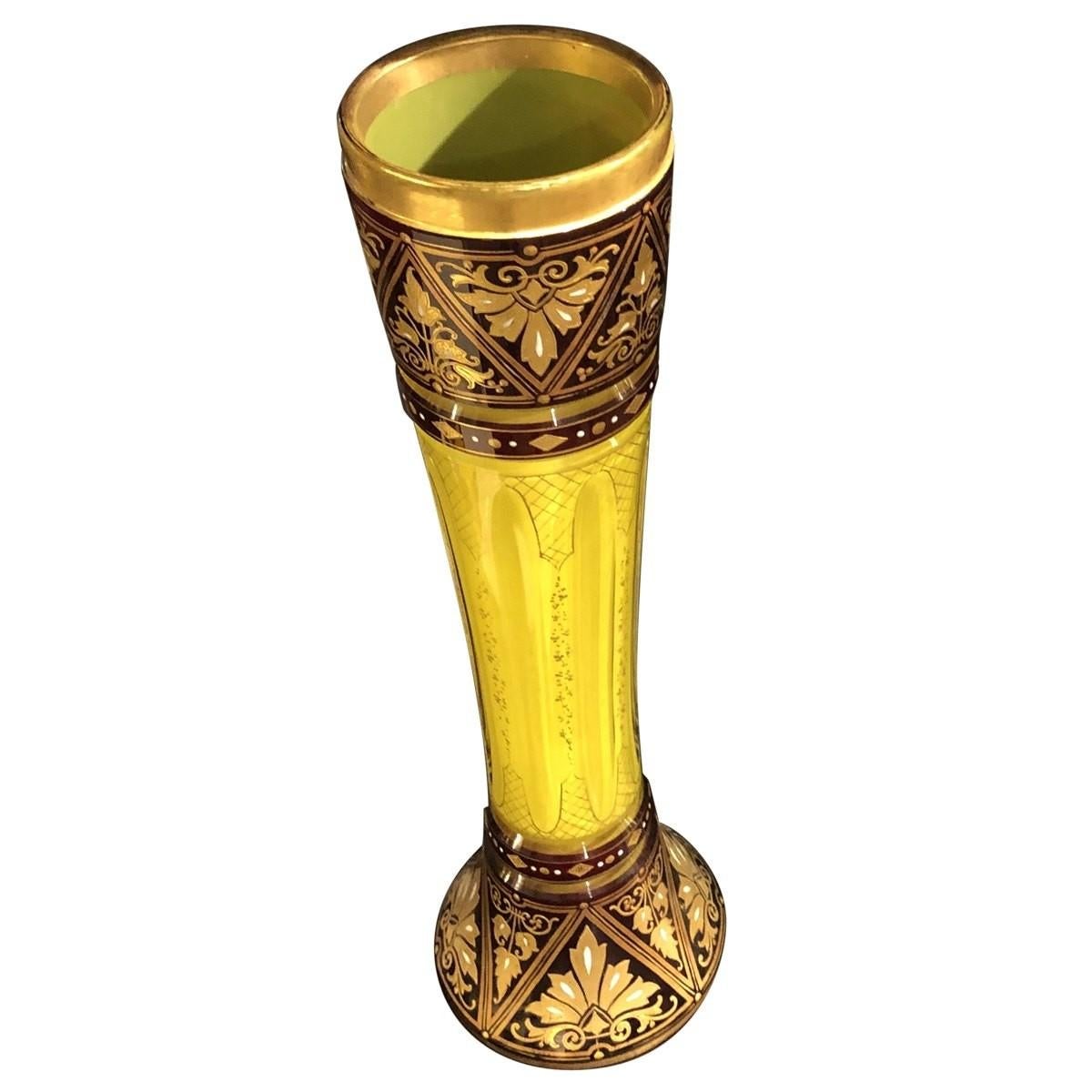 This cut and enameled vase is stately and elegant. The vase is decorated with the Moser style with raised gilt design on burgundy enamel ground. The interior is flashed in vibrant yellow, bringing in warmth and brightness to your space. Place this