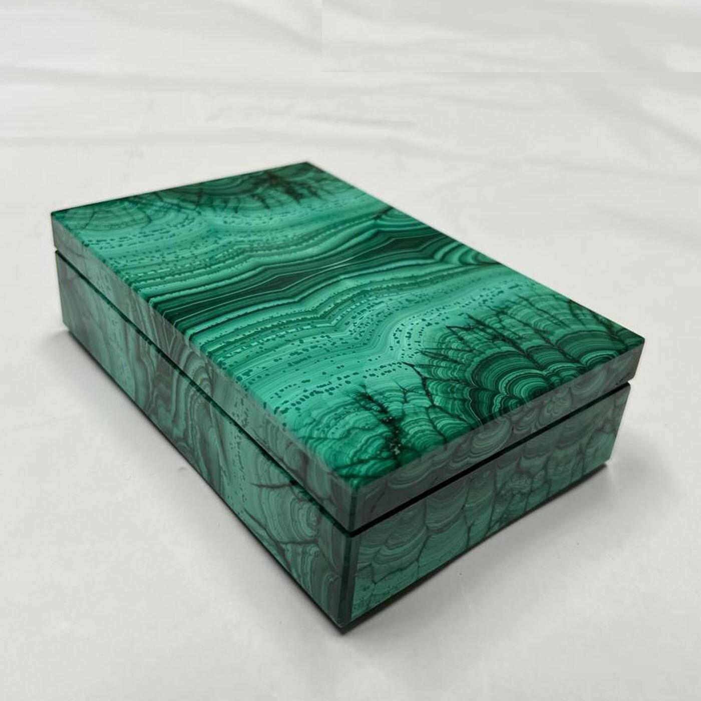 Cette boîte à bijoux en malachite précieuse frappe par ses tracés sensuels et inusables. Ses tons verts éclatants - inspirés de l'ancienne oasis de Bahreïn dédiée à Osiris, déesse de la résurrection - en font la pièce d'appoint idéale pour animer