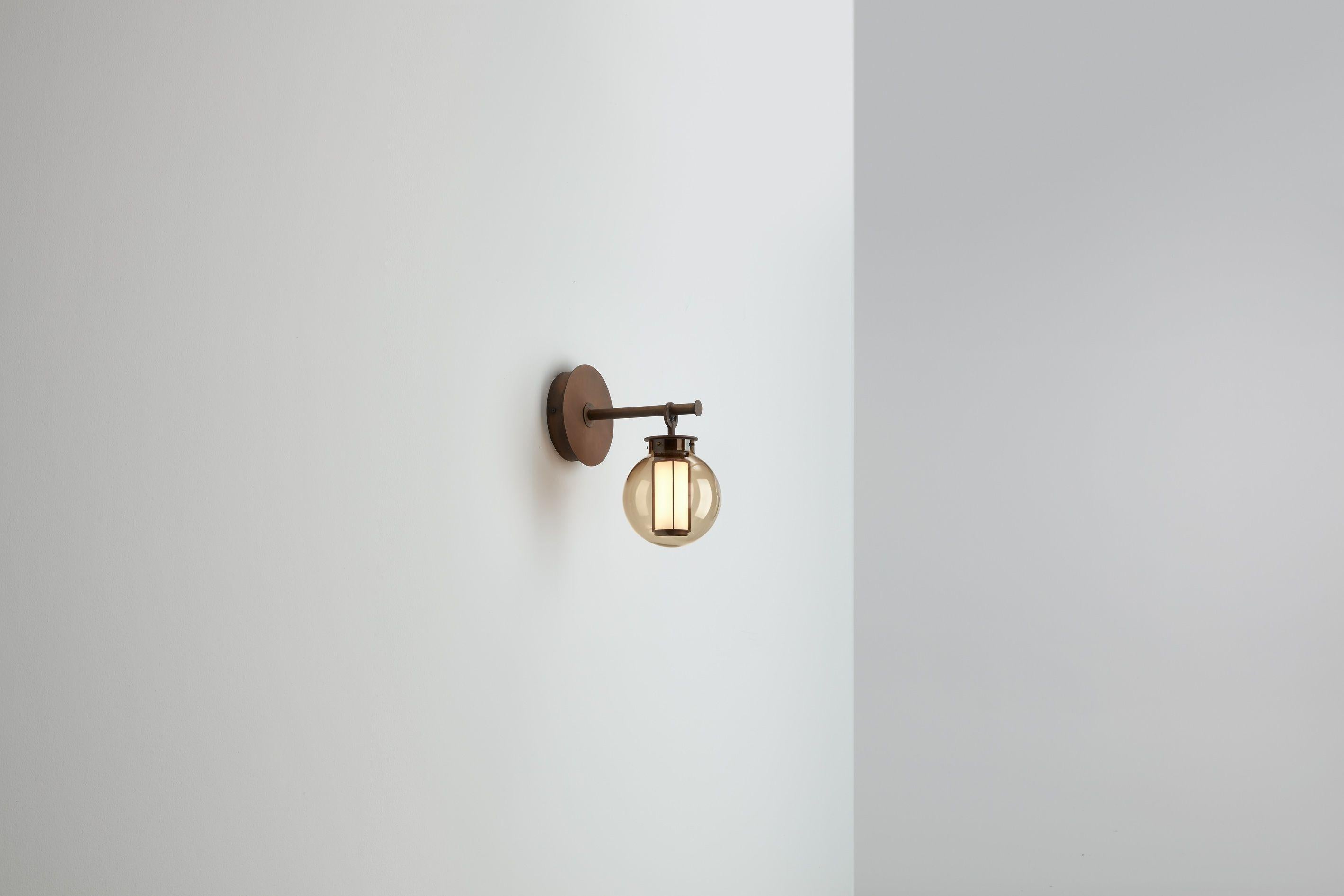 BAI A DI DI 

Lampada da parete. Struttura in acciaio galvanizzato al bronzo. Diffusore in vetro soffiato trasparente, ambrato e grigio. Colonna led a striscia e driver dimmerabile da 1-10V incluso
Di Neri & Hu, 2014. 
Prodotto da