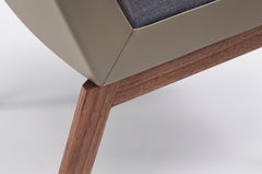 Baia es una silla con un respaldo envolvente de cuero, 4 patas de madera