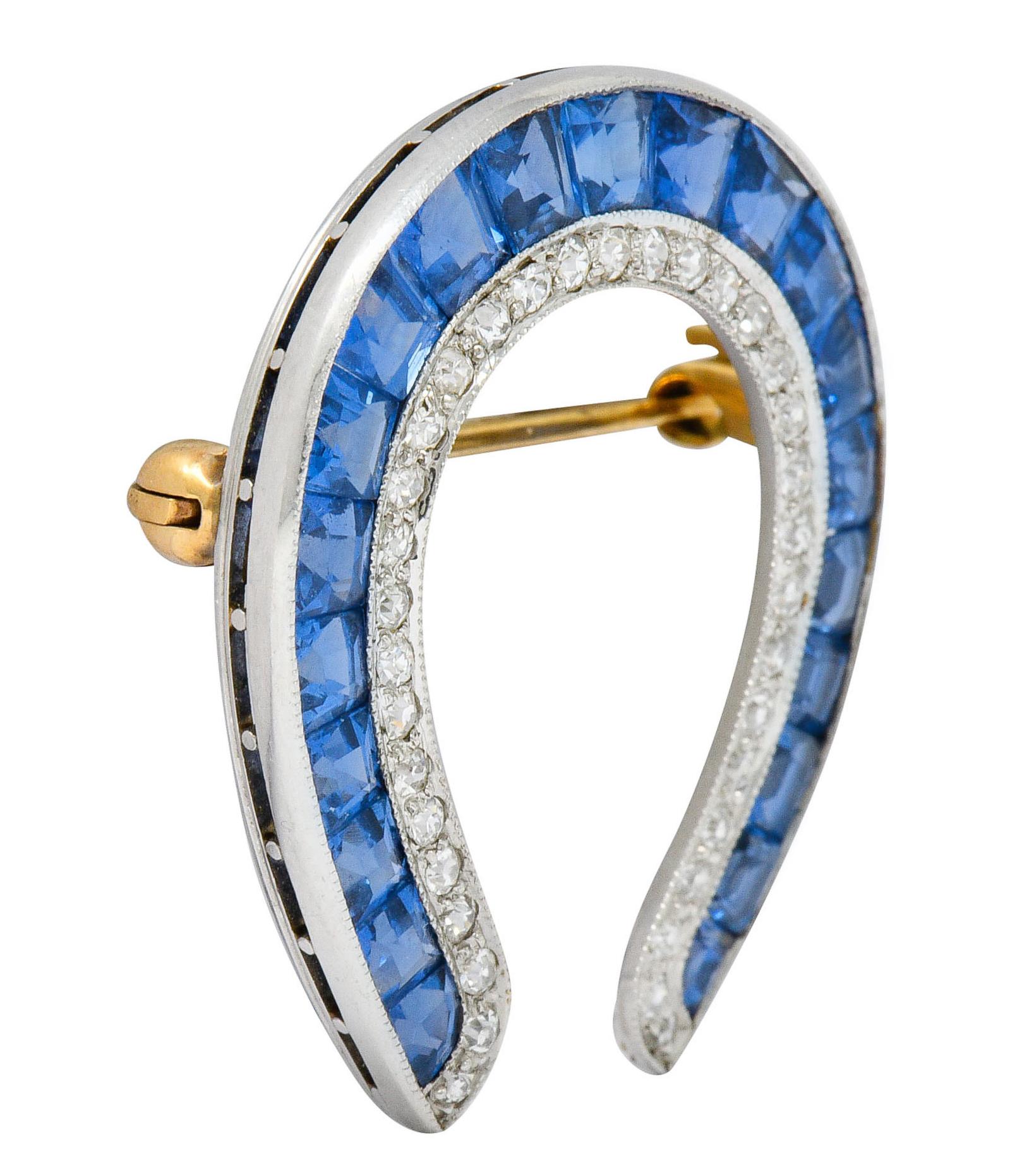 Brooch is designed as a horseshoe channel set with calibrè cut sapphire

Sapphires are very well-matched light violetish-blue color

Accented by single cut diamonds weighing approximately 0.50 carat; eye-clean and white

Completed by 14 karat gold